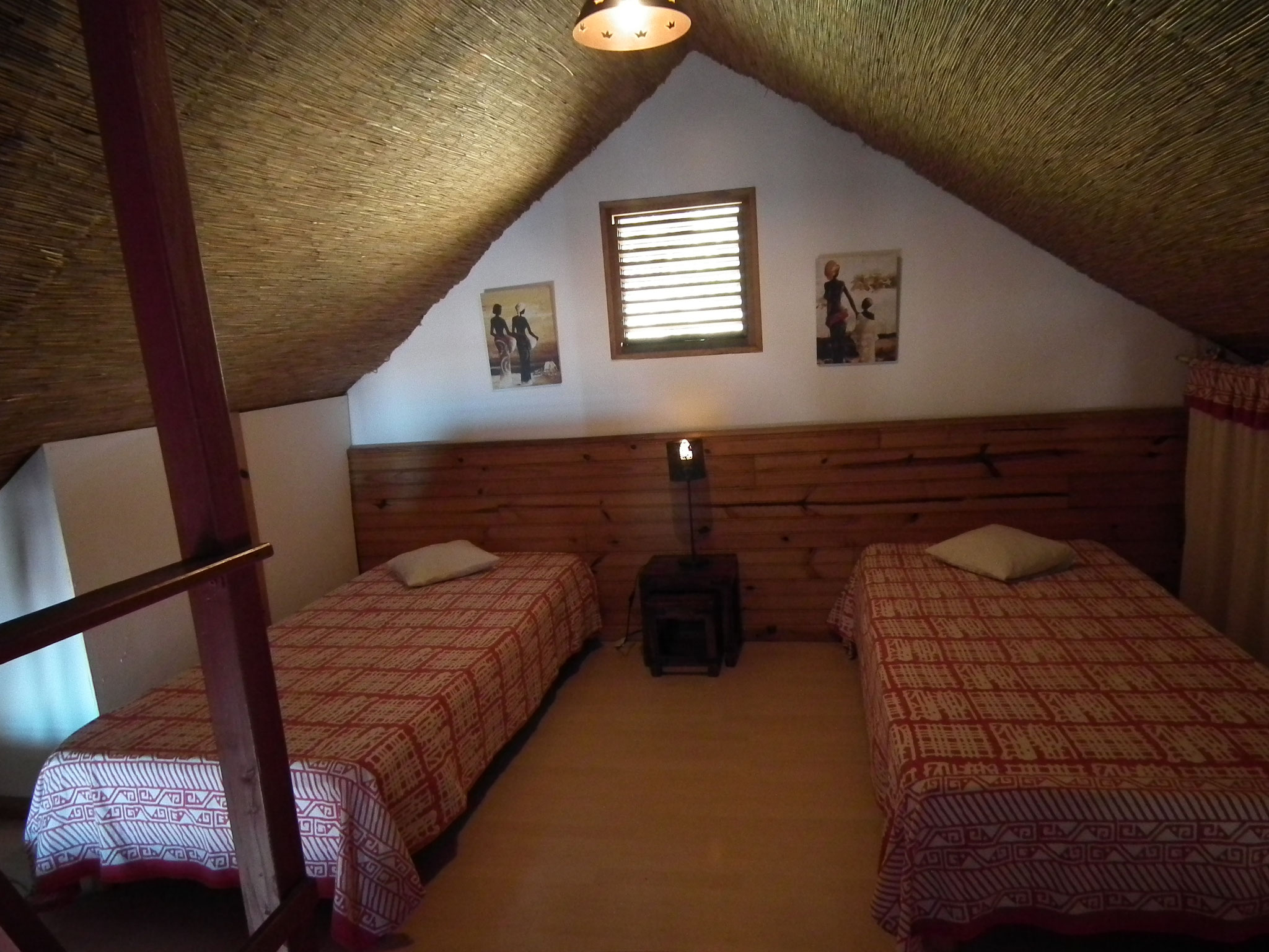 Twin bedroom under the eaves with wooden headboard and warm lighting, Bungalow 9, family bungalow Saint-Leu