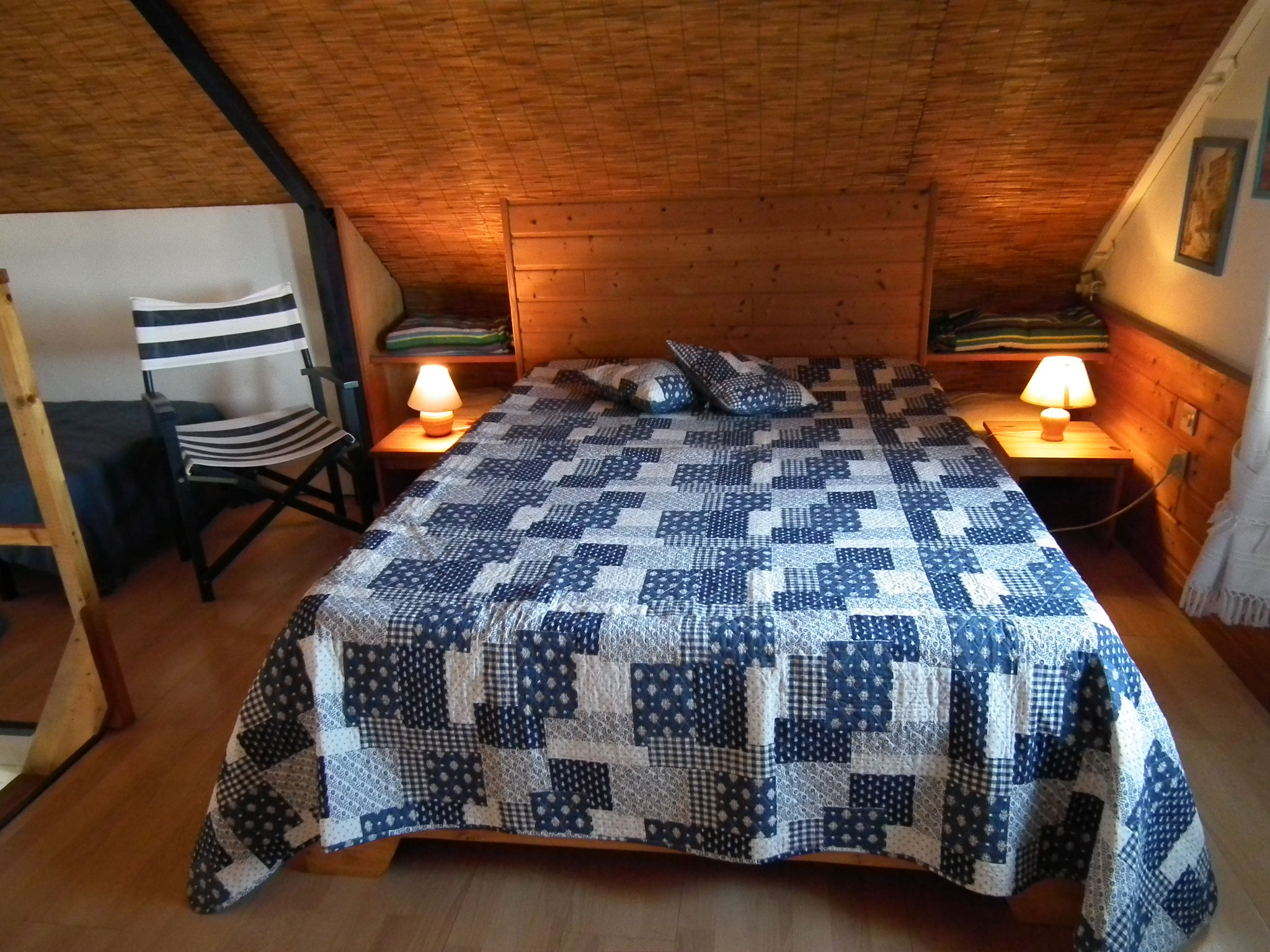 Mezzanine bungalow n°7 – lit double avec couvre-lit patchwork, ambiance chaleureuse
