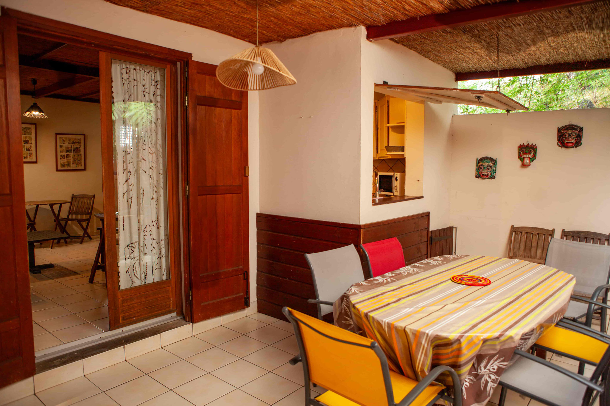 Bright dining room with orange chairs and wooden ceiling, Bungalow 10, holiday bungalow rental Reunion Island