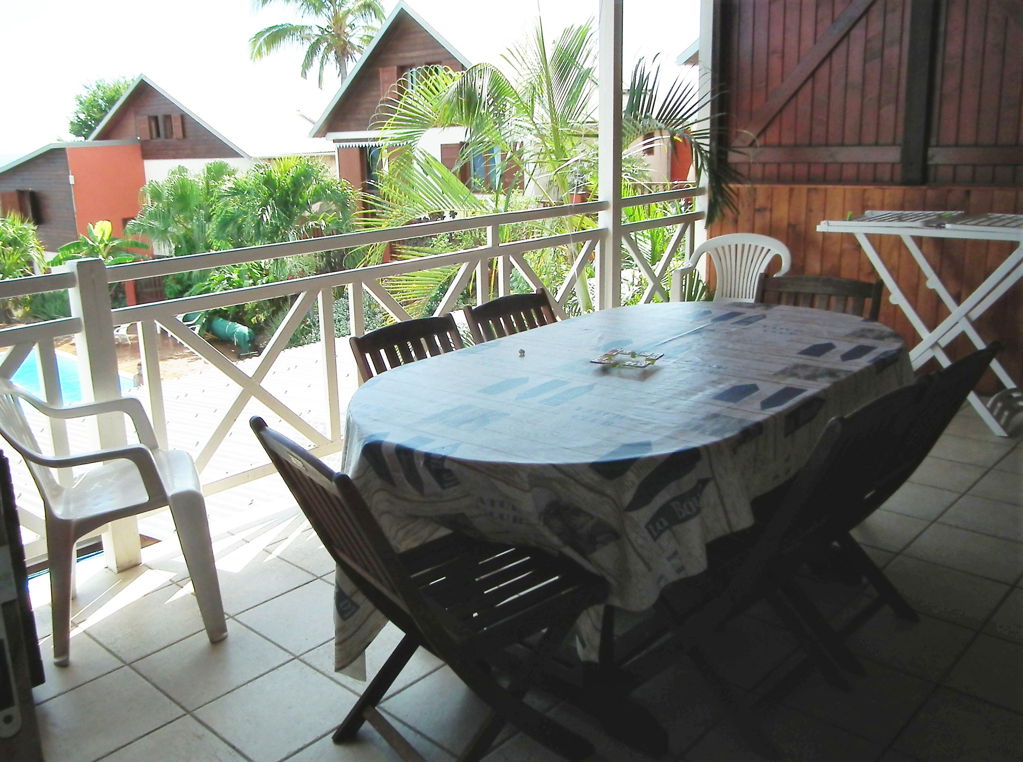 Covered terrace with wooden railing and tropical garden view, Bungalow 9, Le Cardinal des Grands Bleus Saint-Leu