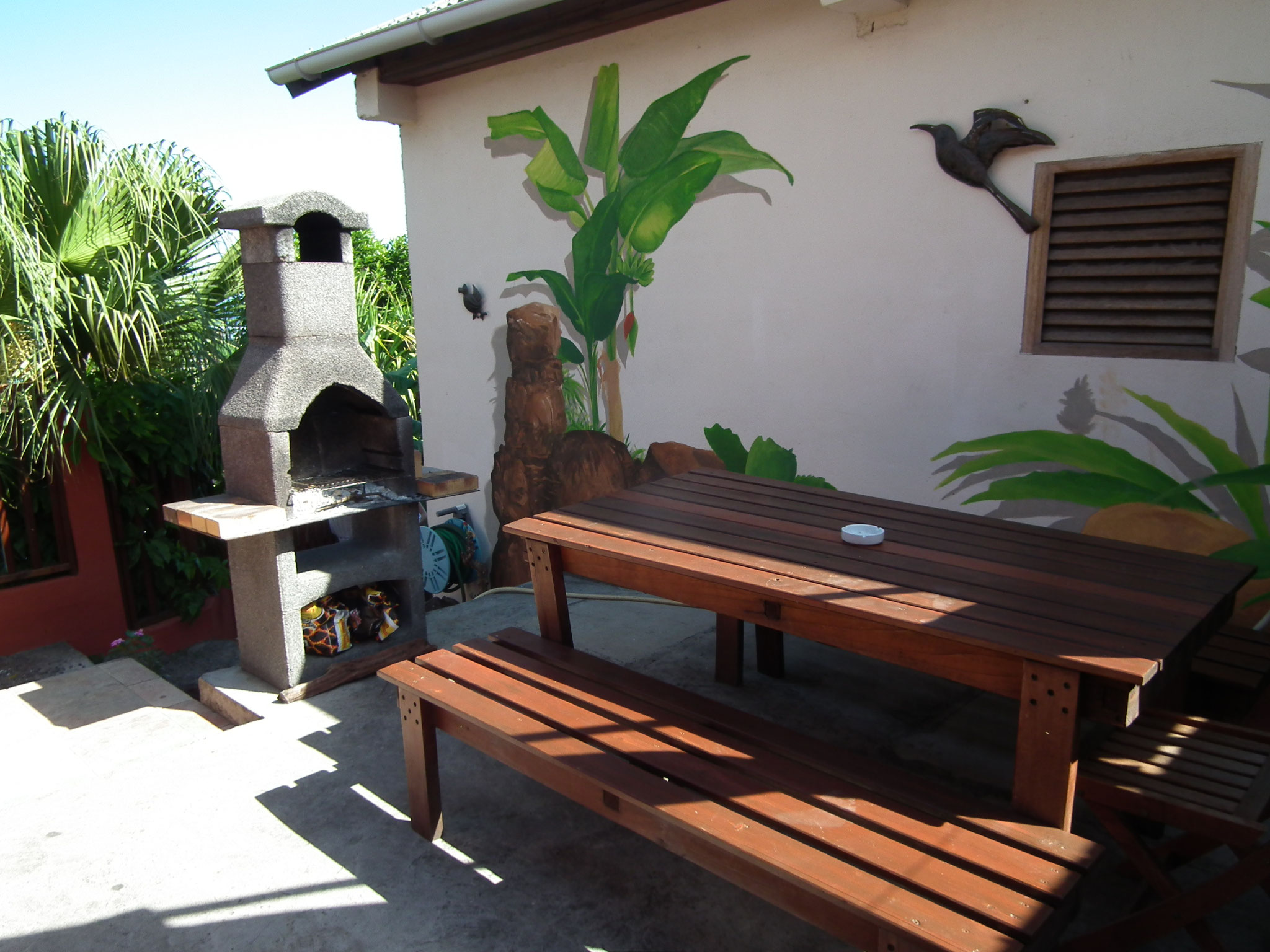 Terrasse bungalow n°7 – barbecue privatif en pierre, table et bancs extérieurs