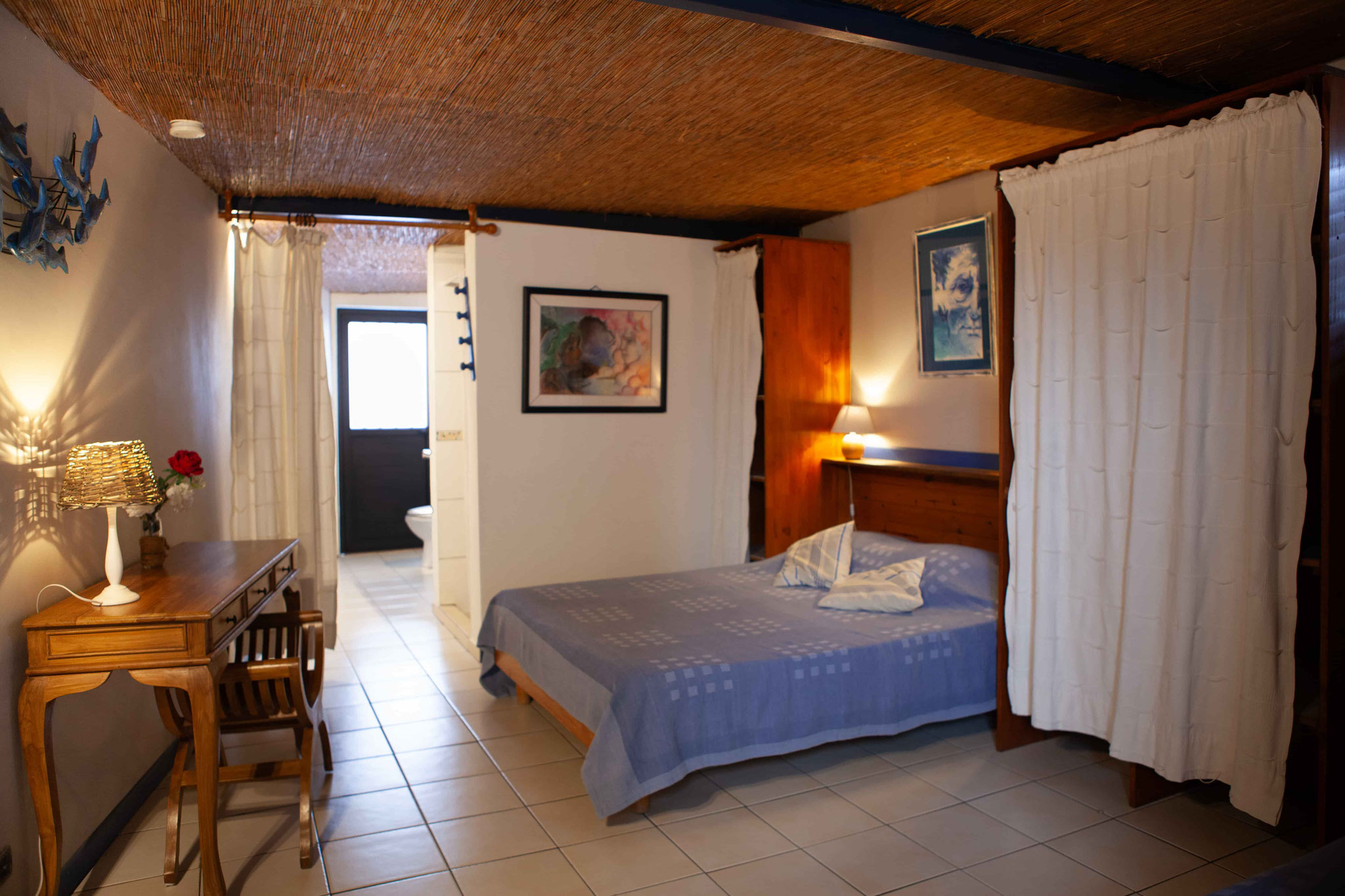 Bedroom 1 ground floor bungalow No.10 – double bed 140×190, en-suite bathroom access, thatched ceiling, marine décor
