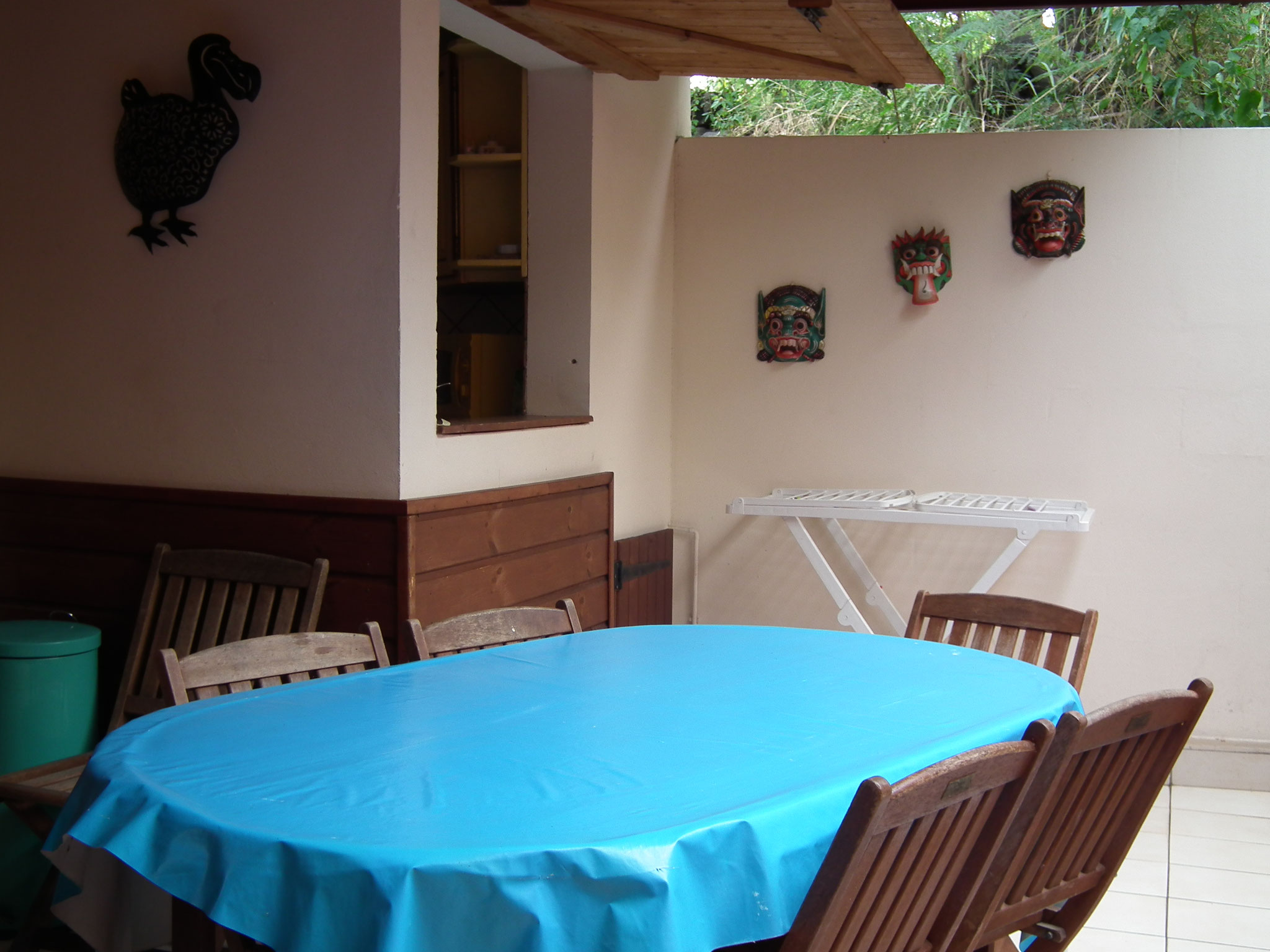 Terrasse couverte bungalow n°10 – coin repas, table et chaises, nappe bleue