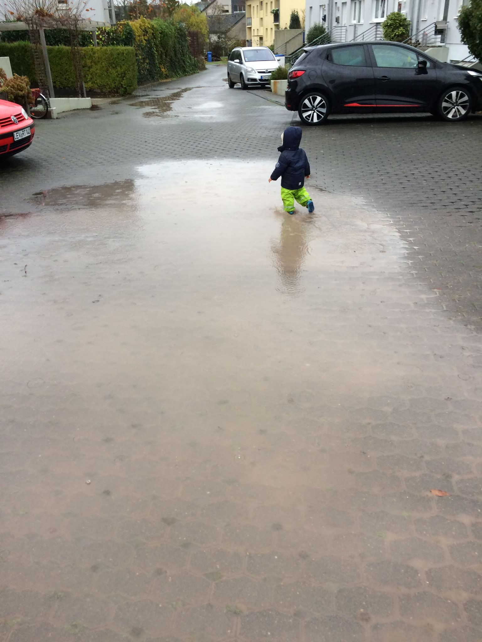 Auch bei Regen geht es raus um in der Pfütze zu spielen
