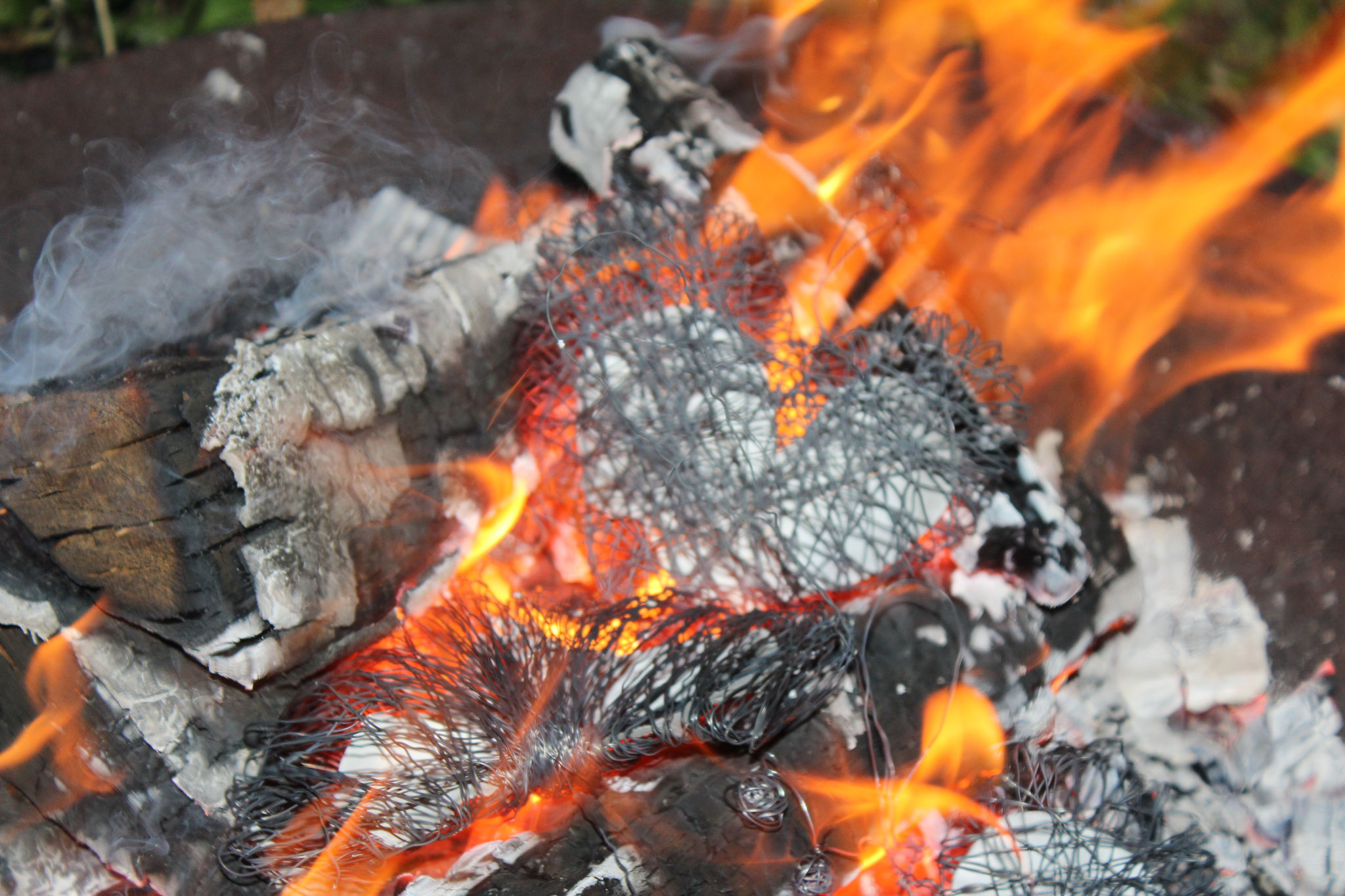 Ein selbst gebasteltes Herz dem Feuer übergeben