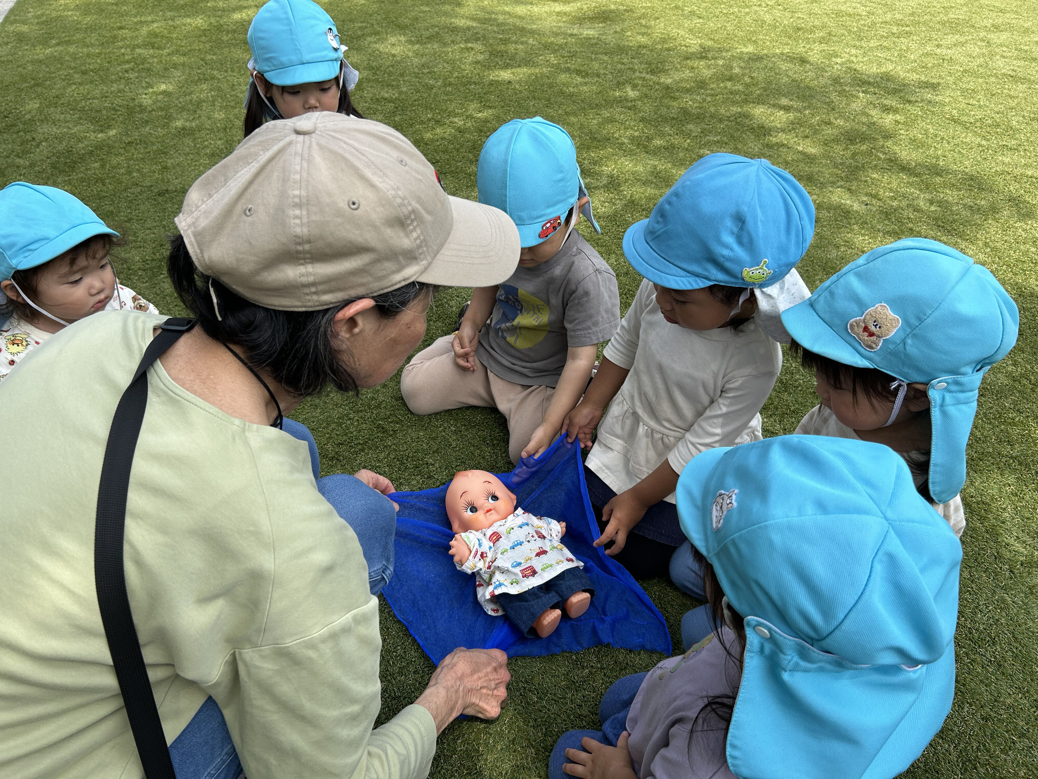 わらべうたです。この日はさわやかなお天気でお庭でお人形を歌に合わせてゆらゆらしました。