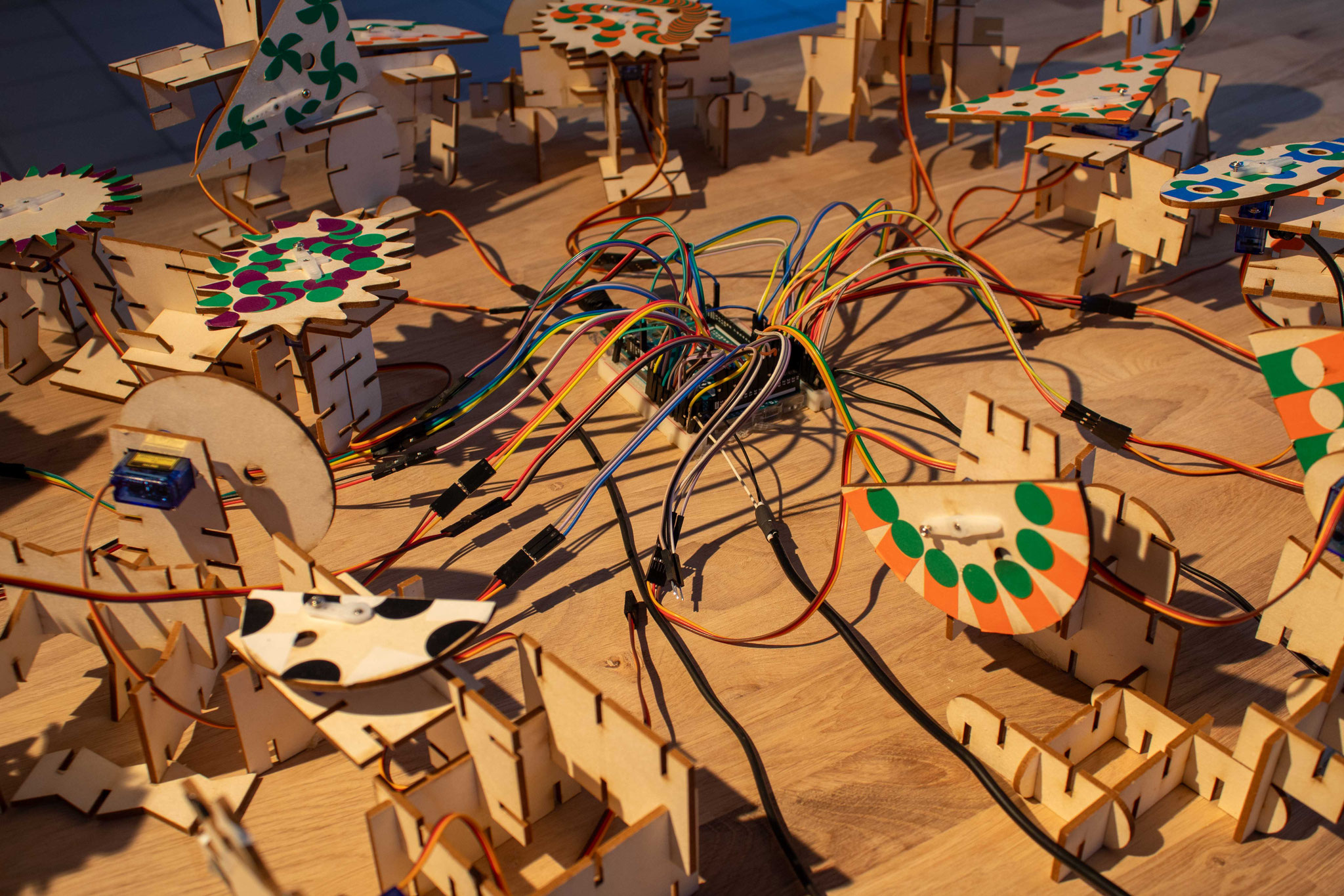 Sculptures mécatroniques, servomoteurs, microcontrôleur, breadboard, enceintes, table de mixage, jacks, microphones à bobinage, gommettes, fils électriques, alimentation électrique, vis, carton bois, 2024. Résultats des rencontres avec les scolaires.