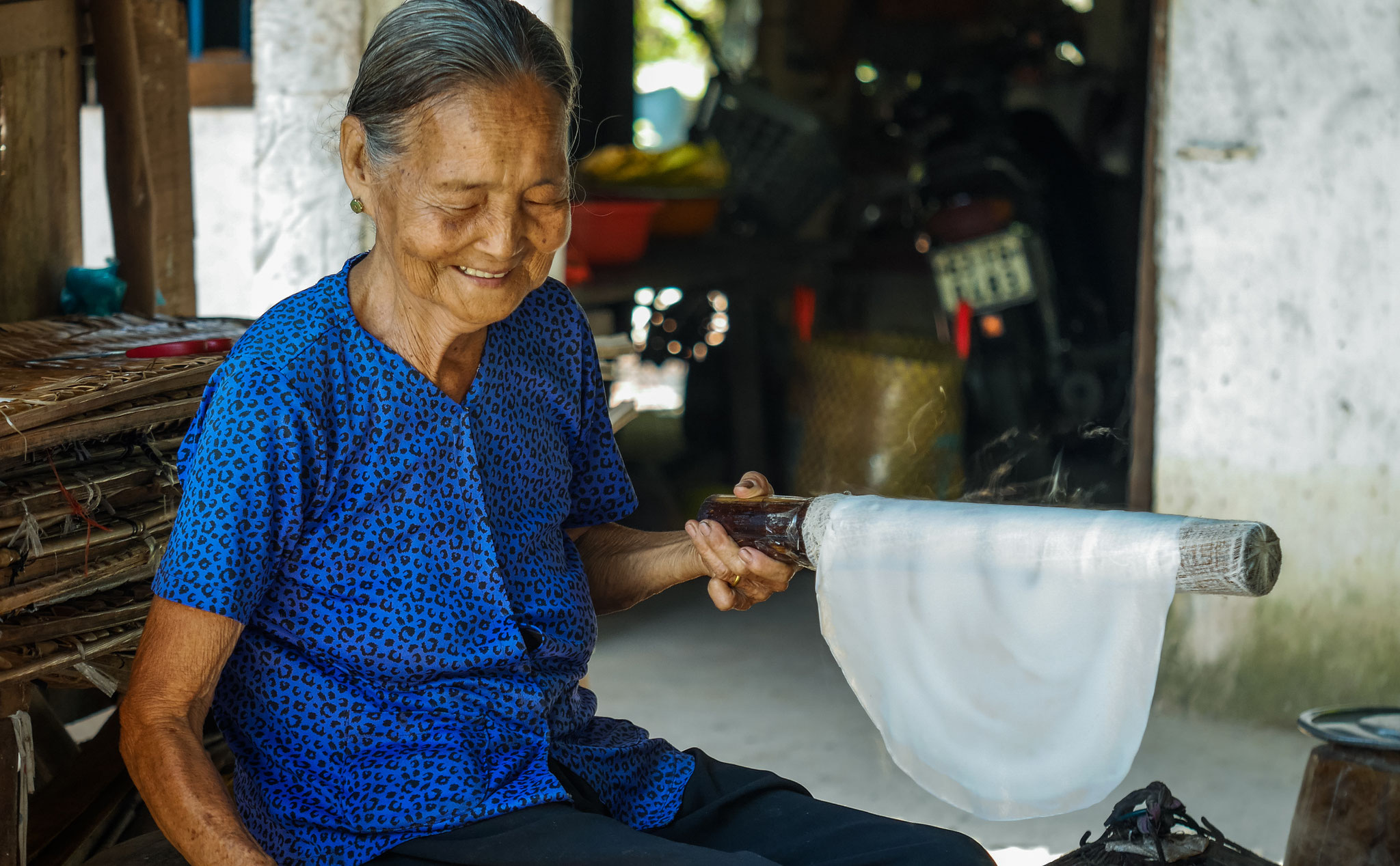 "alte Frau" im Mekong Delta beim Herstellen der Reispapier