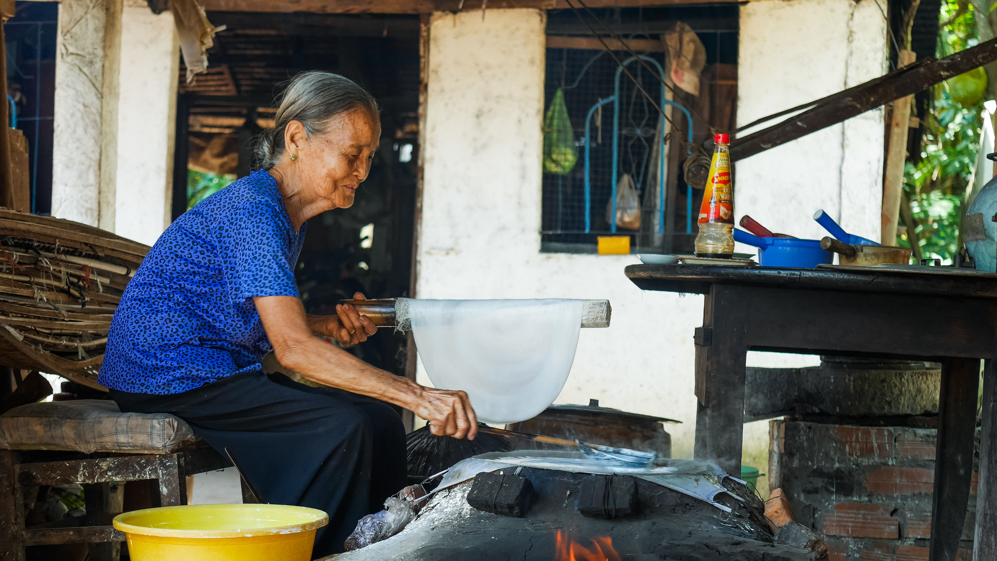 "alte Frau" im Mekong Delta beim Herstellen der Reispapier