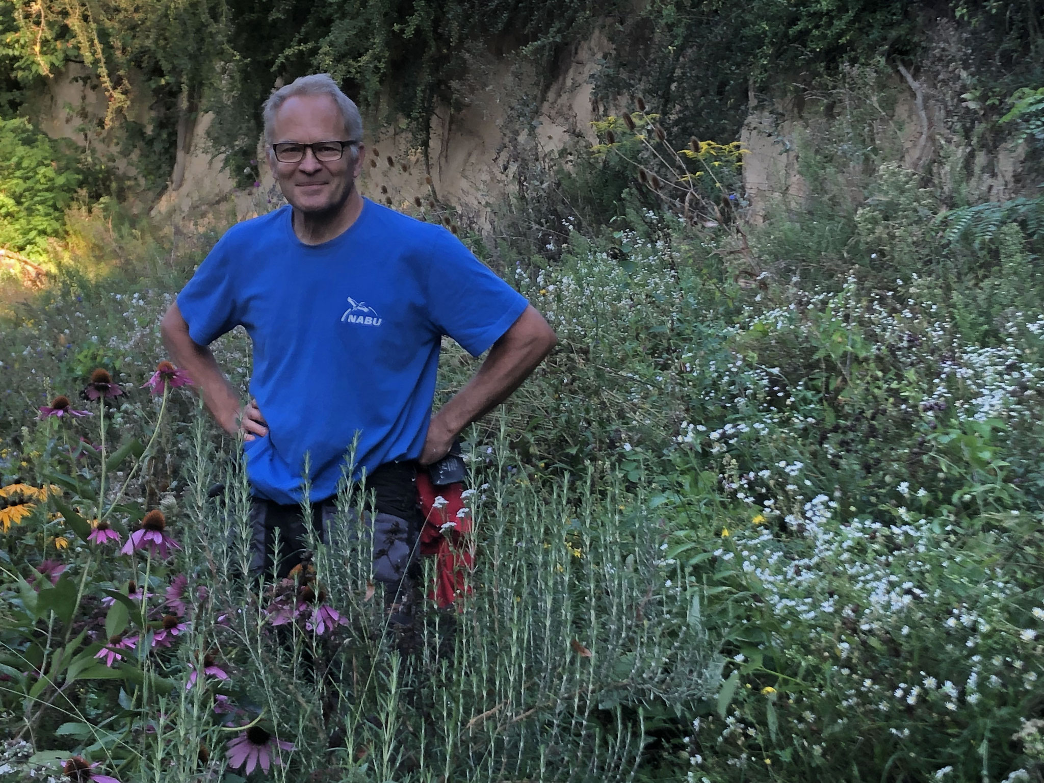 Sommer 2021: Dr. Christoph Aly inmitten des blühenden Wildbienengartens