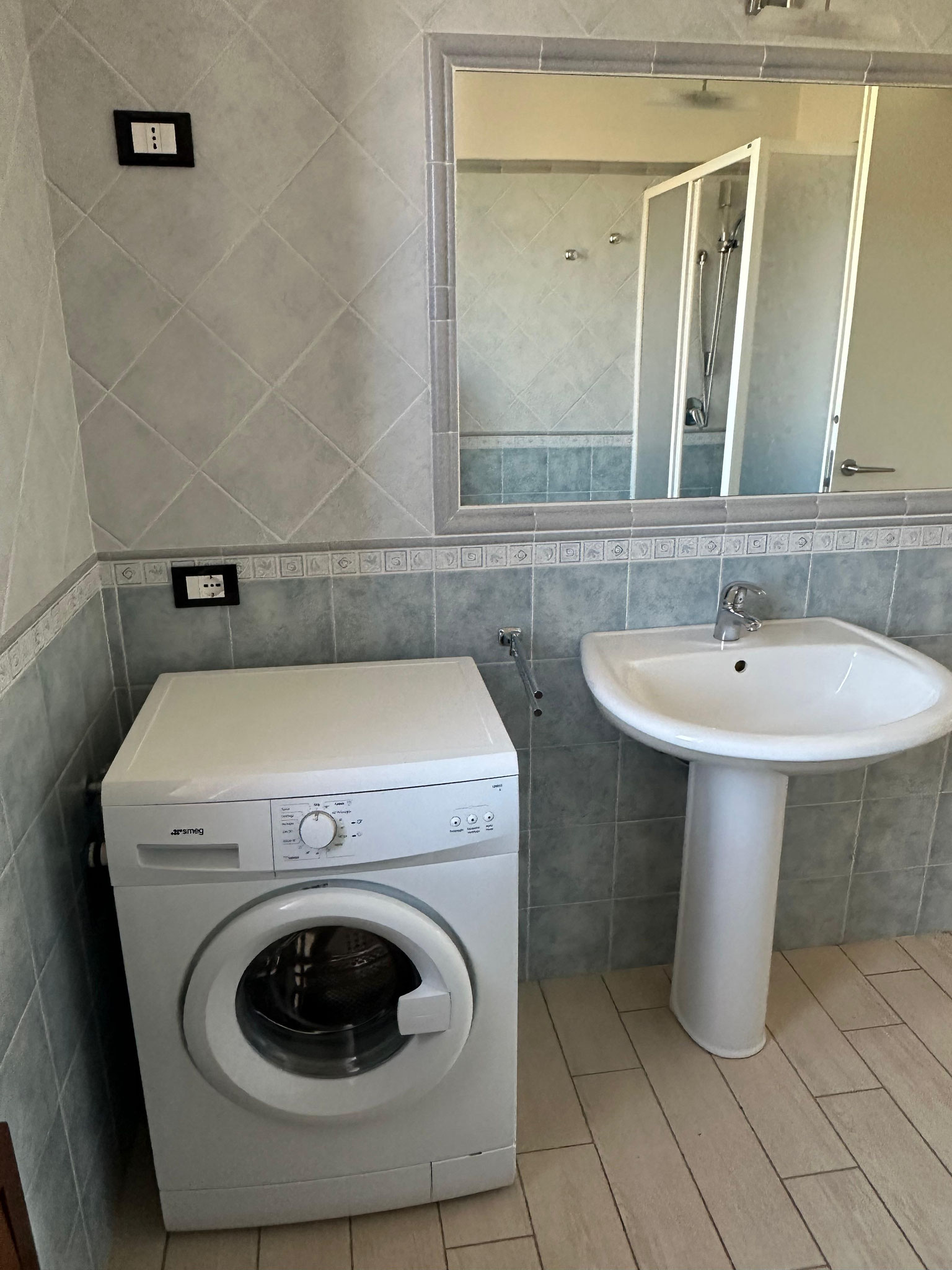 Bagno con doccia e lavatrice