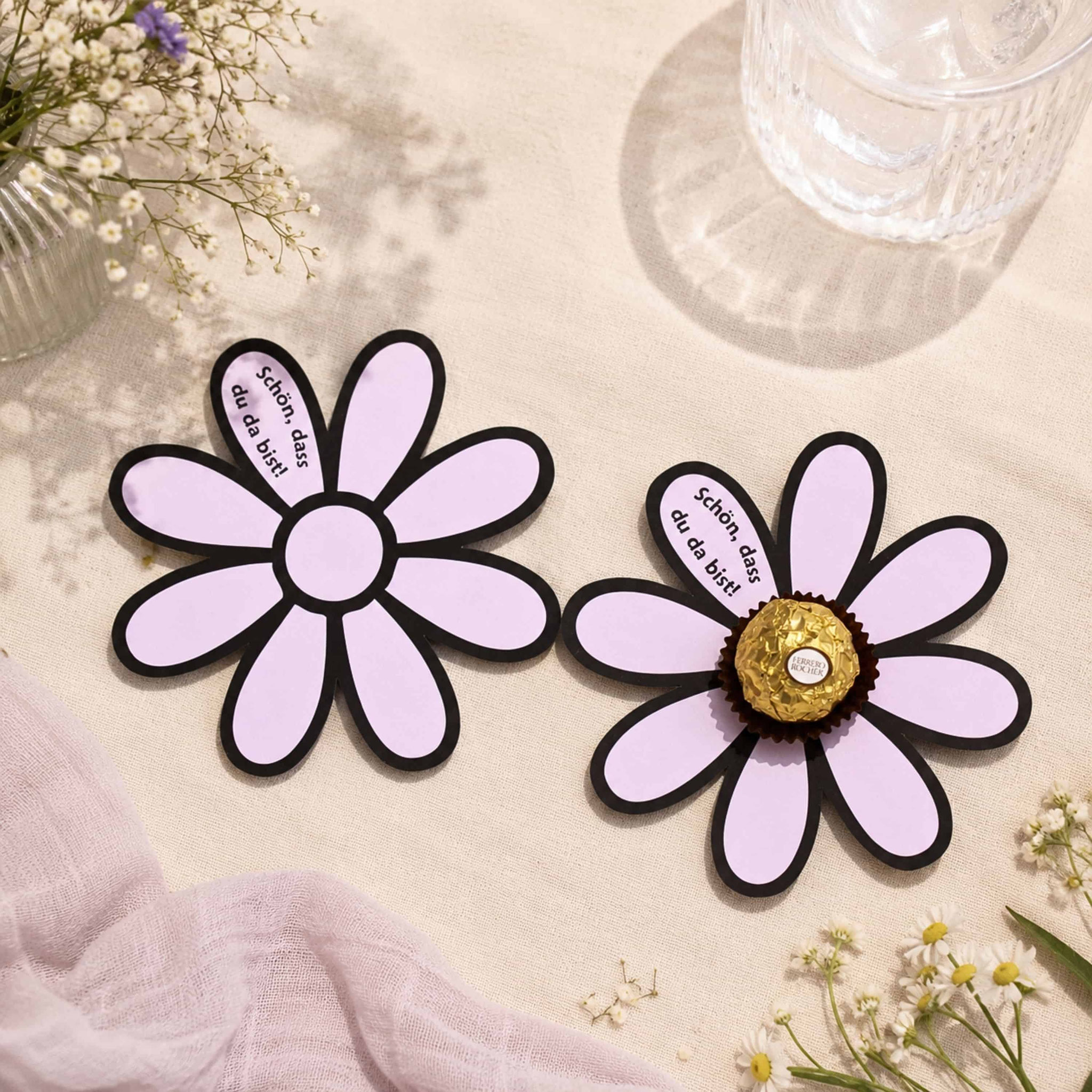 Zwei Papierblumen „Schön, dass du da bist!“ mit Ferrero Rocher als liebevolles DIY‑Gastgeschenk in Tischdeko.