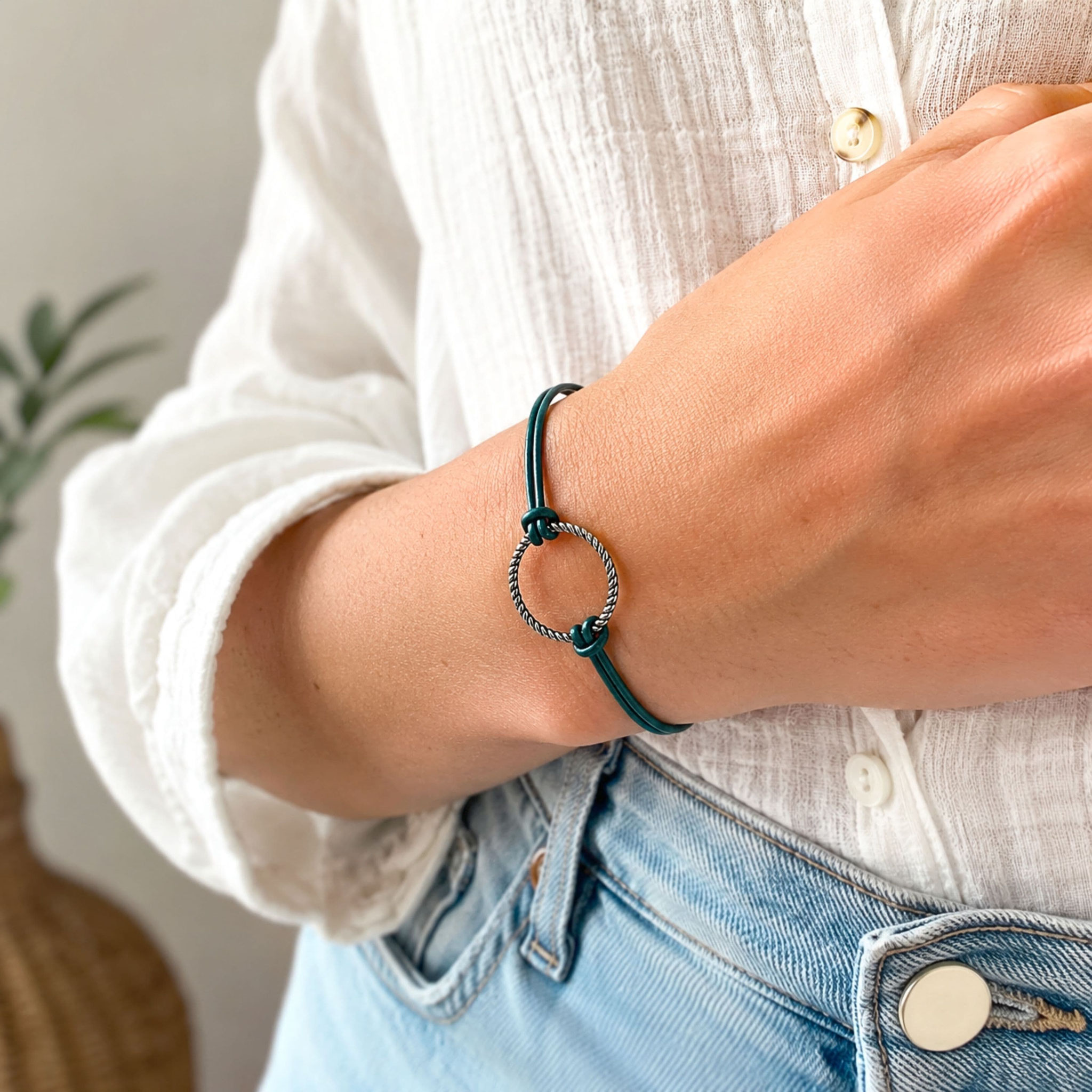 Tragefoto eines grünen Lederarmbands mit silbernem Ringelement am Handgelenk.
