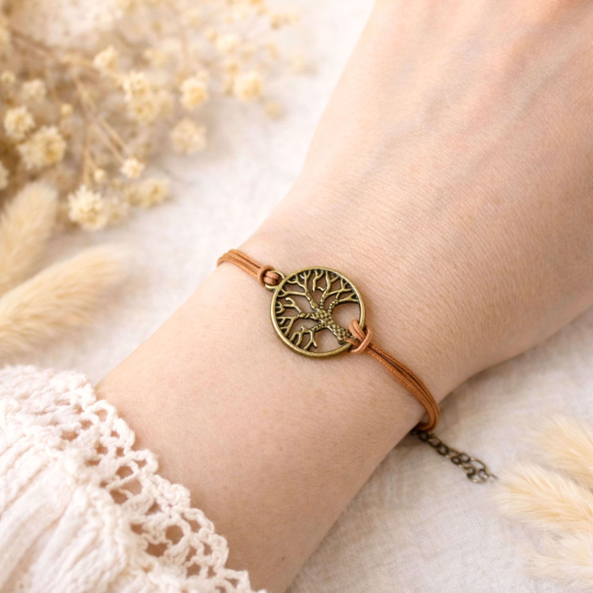 Armband mit Lebensbaum-Anhänger am Handgelenk.