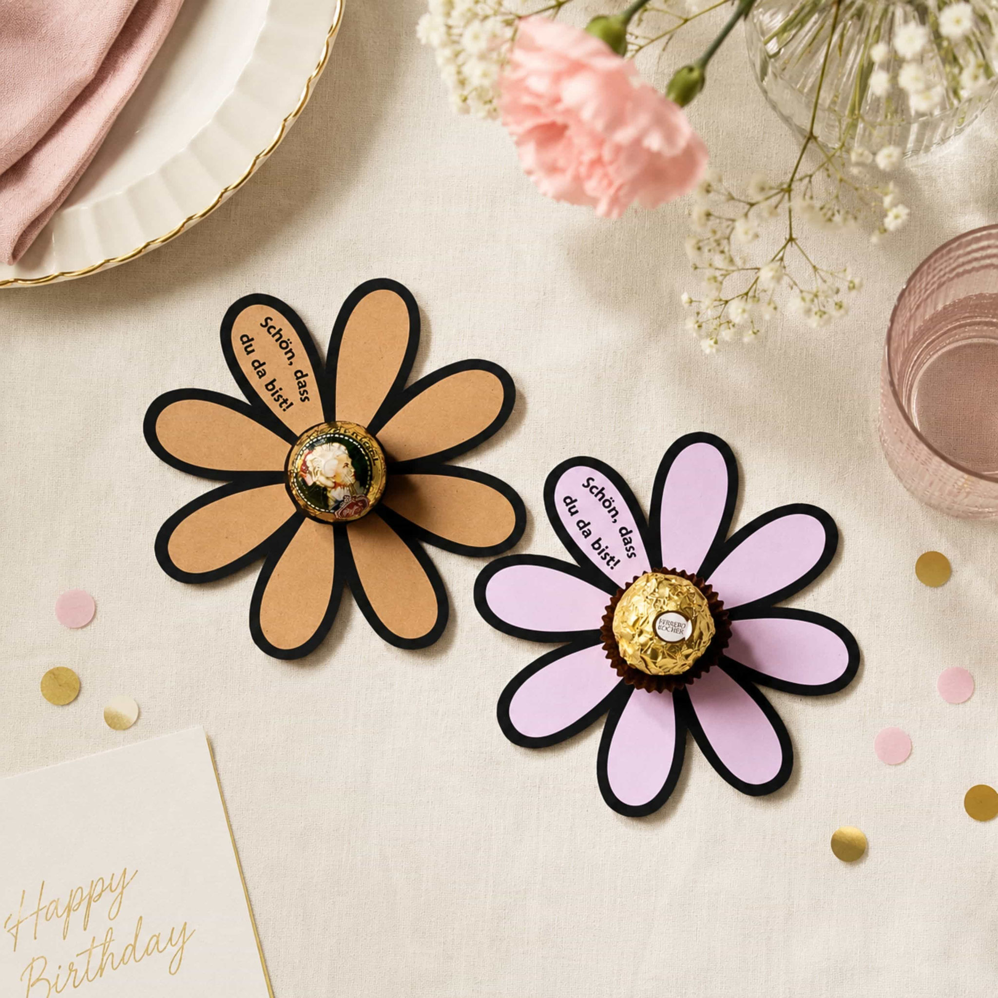 Papierblumen mit Ferrero Rocher als Gastgeschenk „Schön, dass du da bist!“ in festlicher Tischdeko.