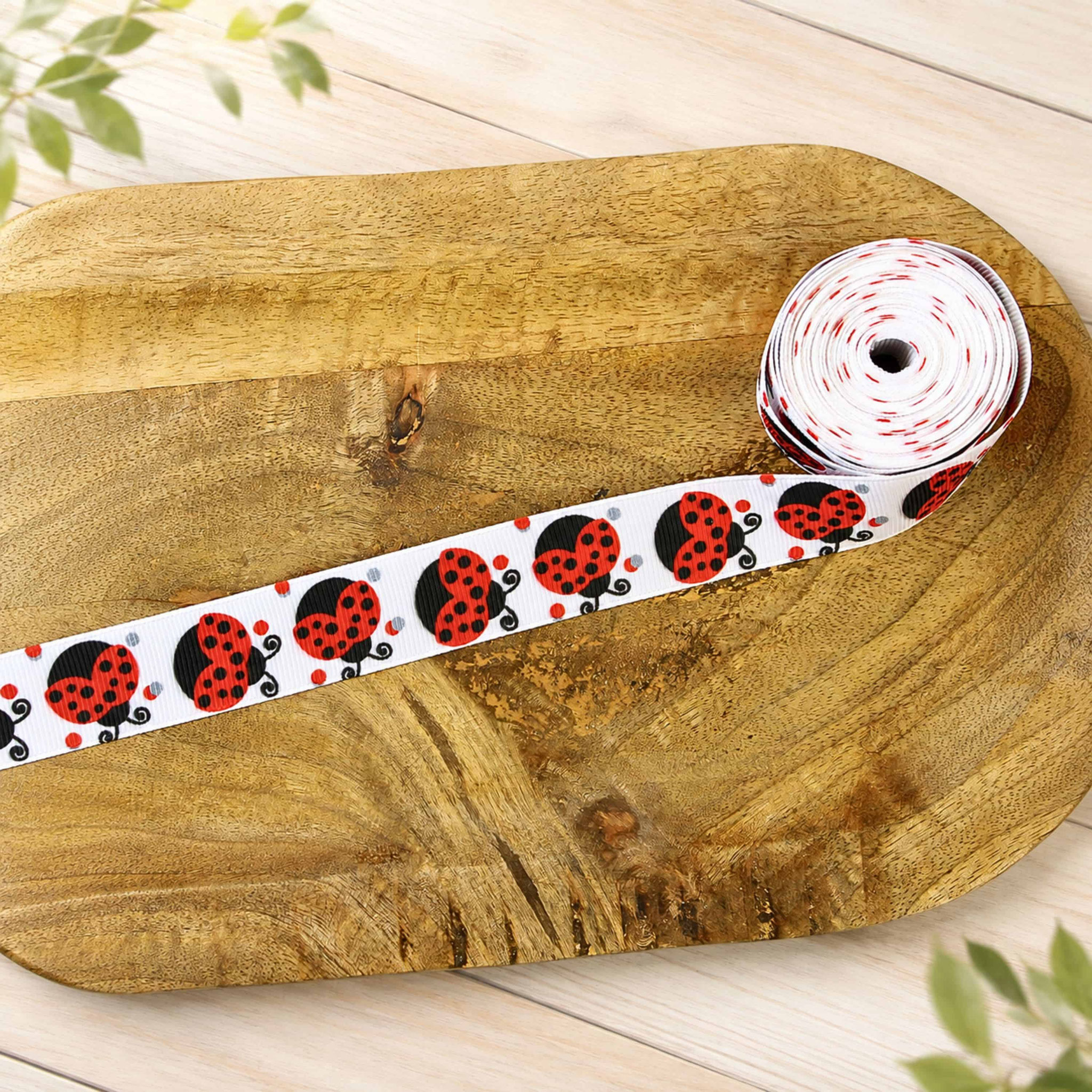 Ripsband mit Marienkäfer-Motiv als Meterware auf Holztablett – ideal für Nähprojekte, Dekorationen und Bastelideen.