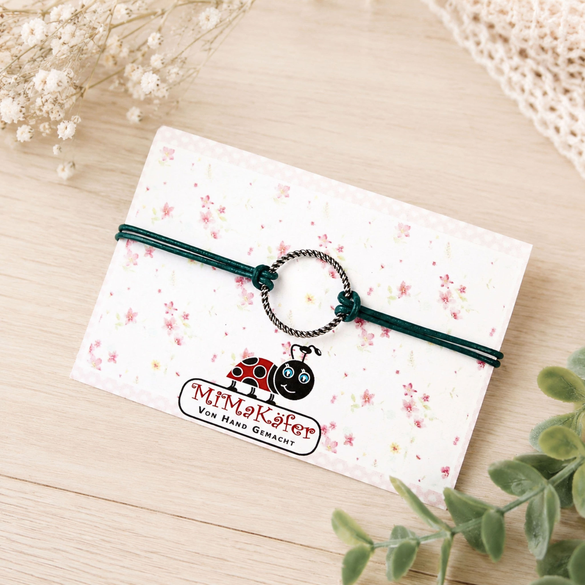 Grünes Lederarmband mit Ringelement auf Schmuckkarte von MiMaKäfer.