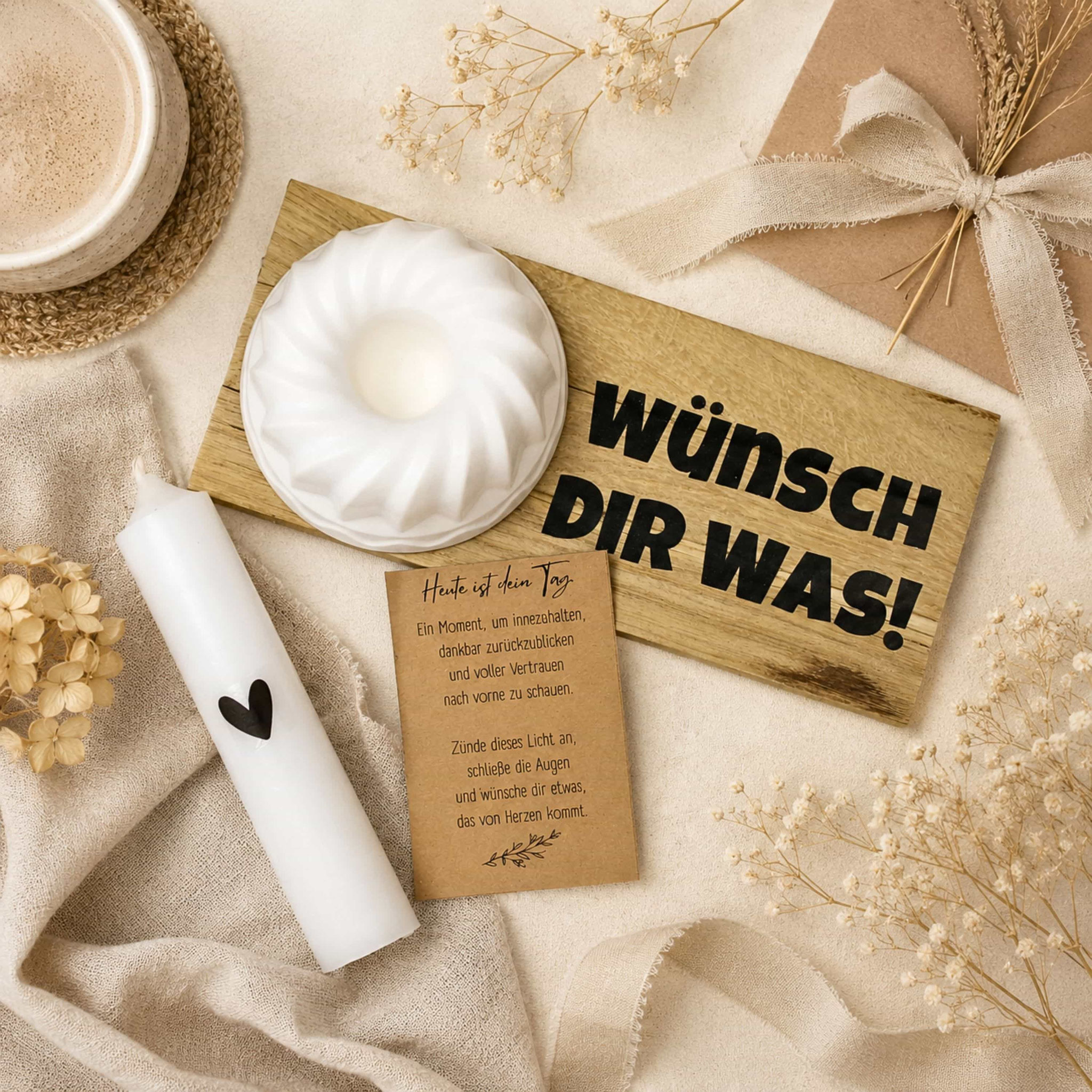 Kerze, Holzbrett „Wünsch dir was“, Karte, Kaffee und Trockenblumen.