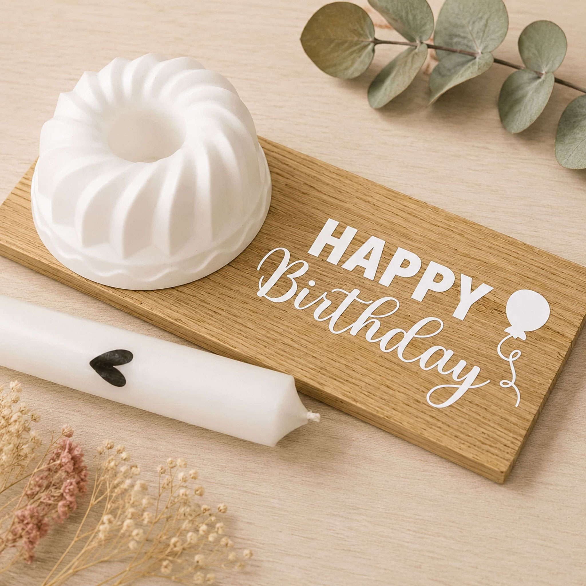 Birthday‑Deko mit Holzbrett „HAPPY Birthday“, Kerzenhalter, Kerze und Trockenblumen.