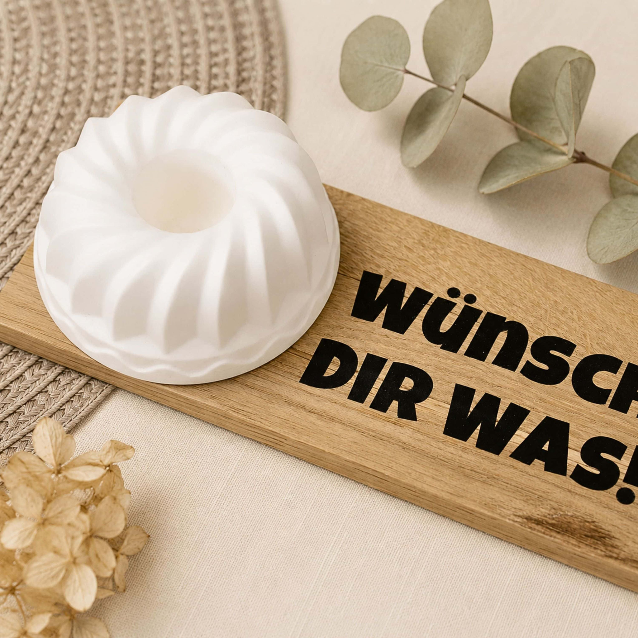 Holzbrett „Wünsch dir was“ mit Kerzenhalter und Trockenblumen.