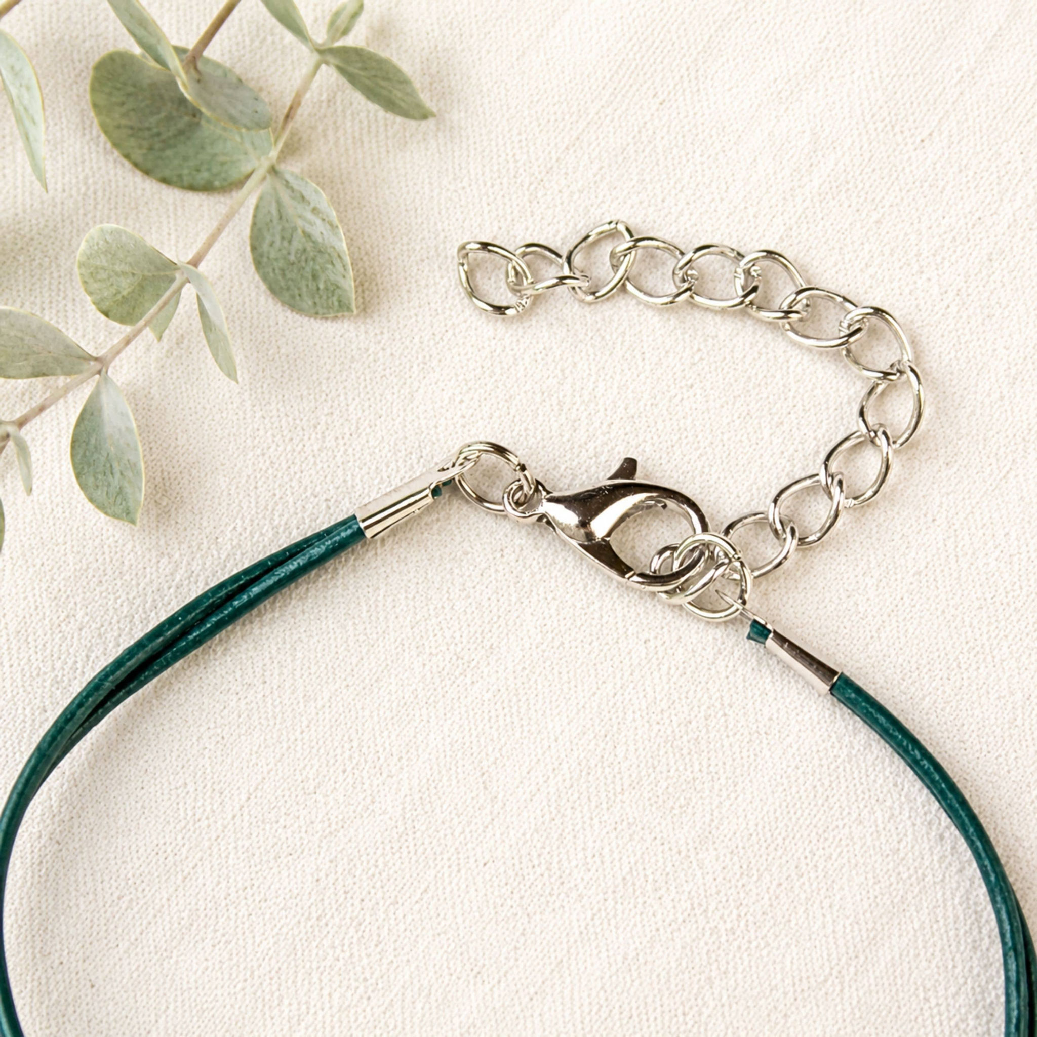 Detailaufnahme des Karabinerverschlusses mit Verlängerungskette am grünen Lederarmband für Damen und Wunschgröße