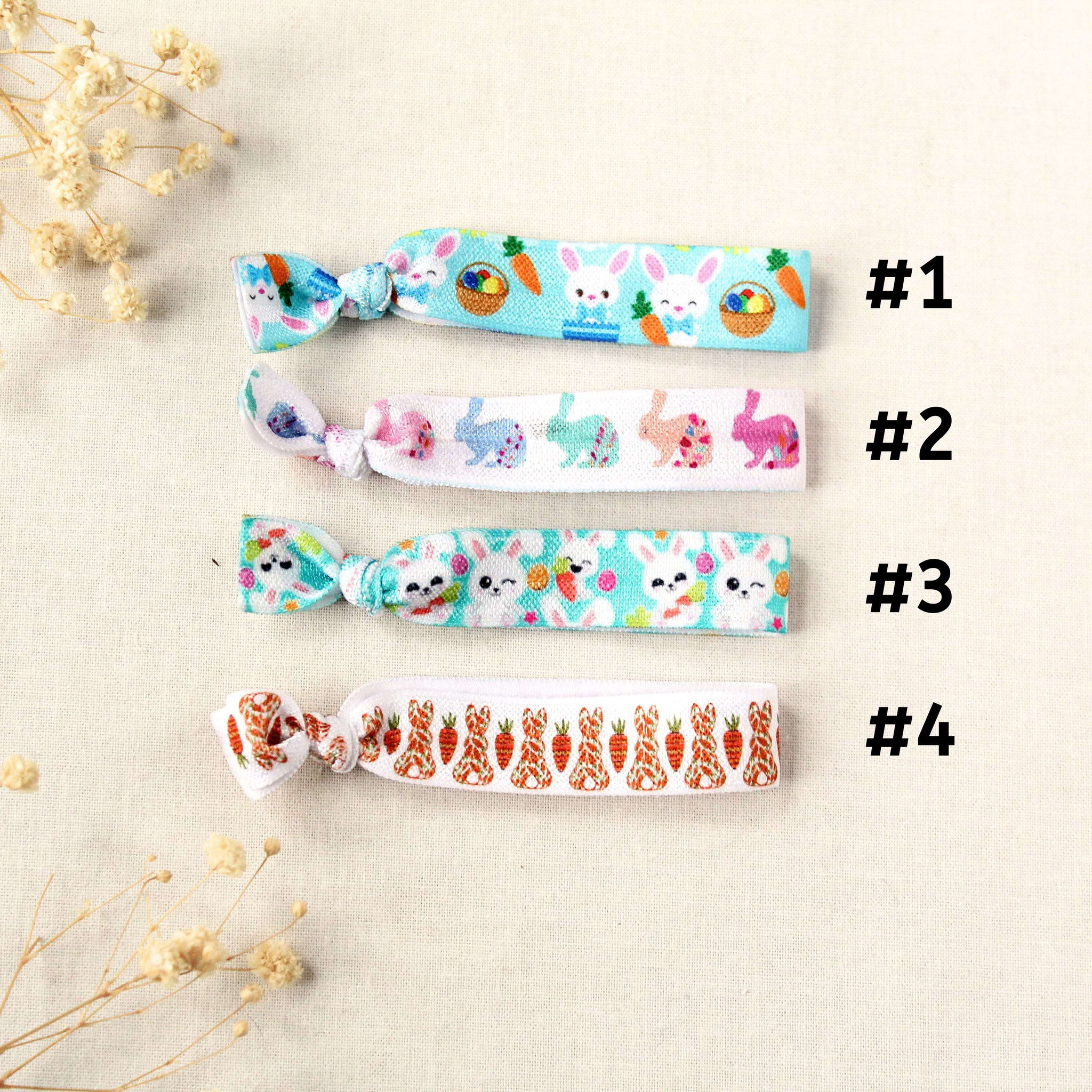 Vier elastische Osterarmbänder mit Hasen- und Karottenmotiven, nummeriert zur Designauswahl im Produktlisting.