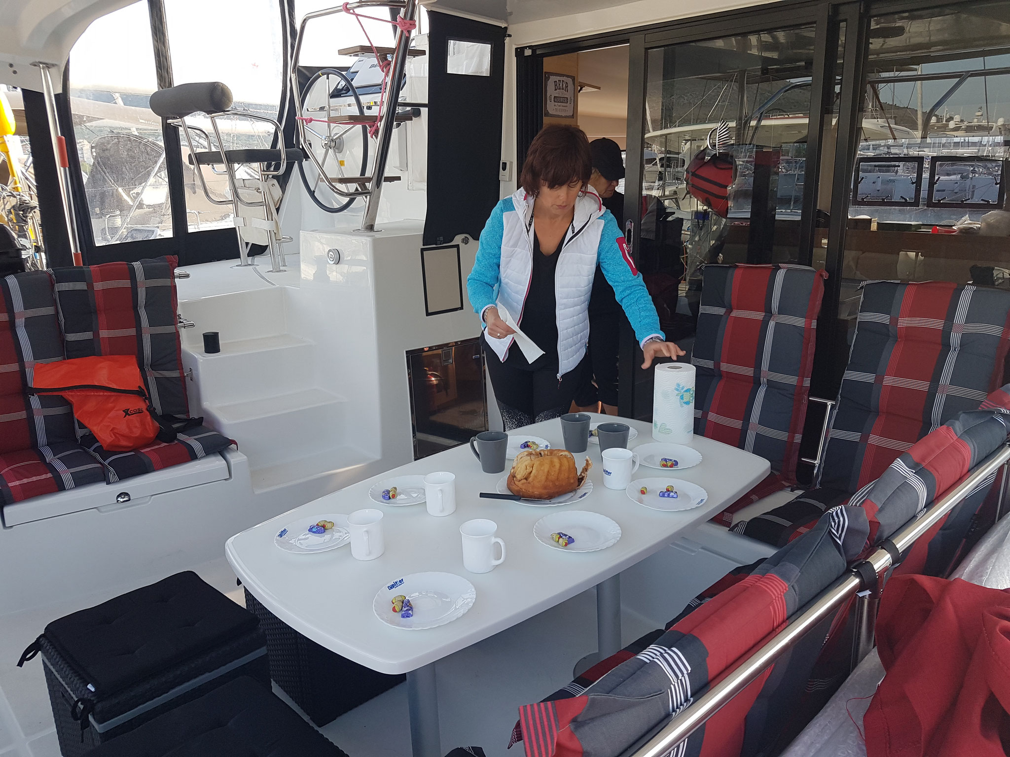 Katamarantrainingsgast deckt den Tisch auf der lagoon 42 Janny