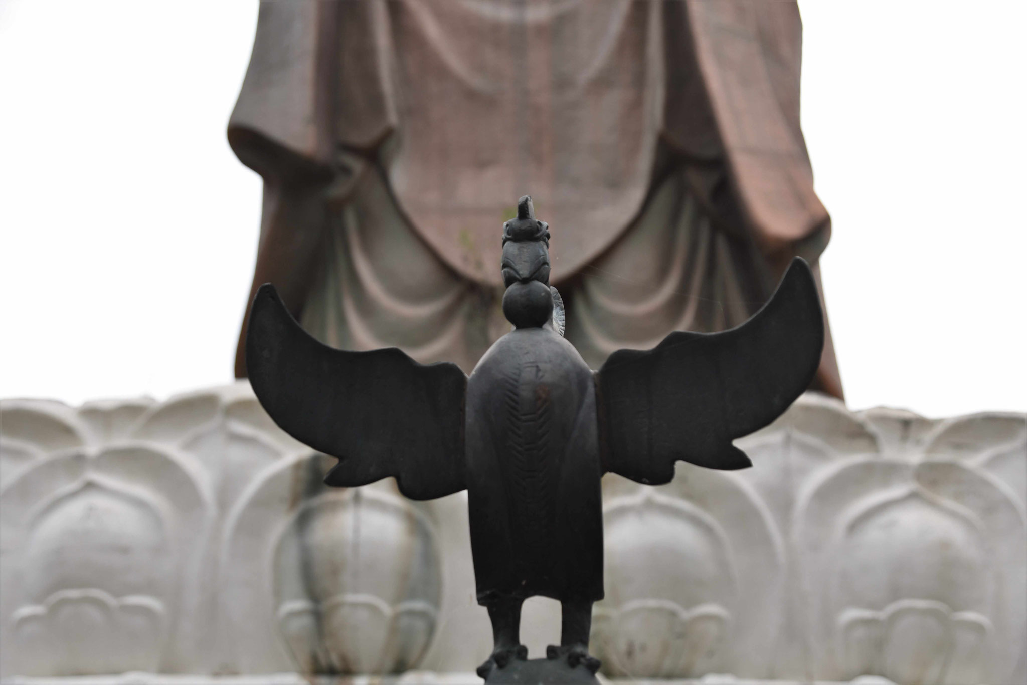 Adler vor Buddha-Statue