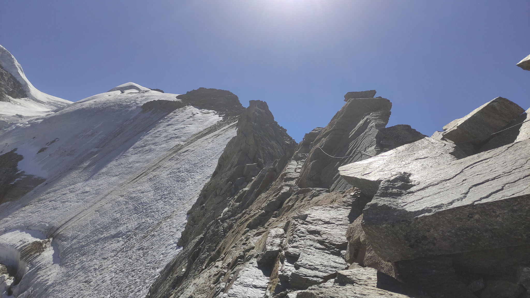Der Klettersteig führt direkt am Grat entlang. Über den spaltenreichen Gletscher links darunter kommt der Normalweg hinauf