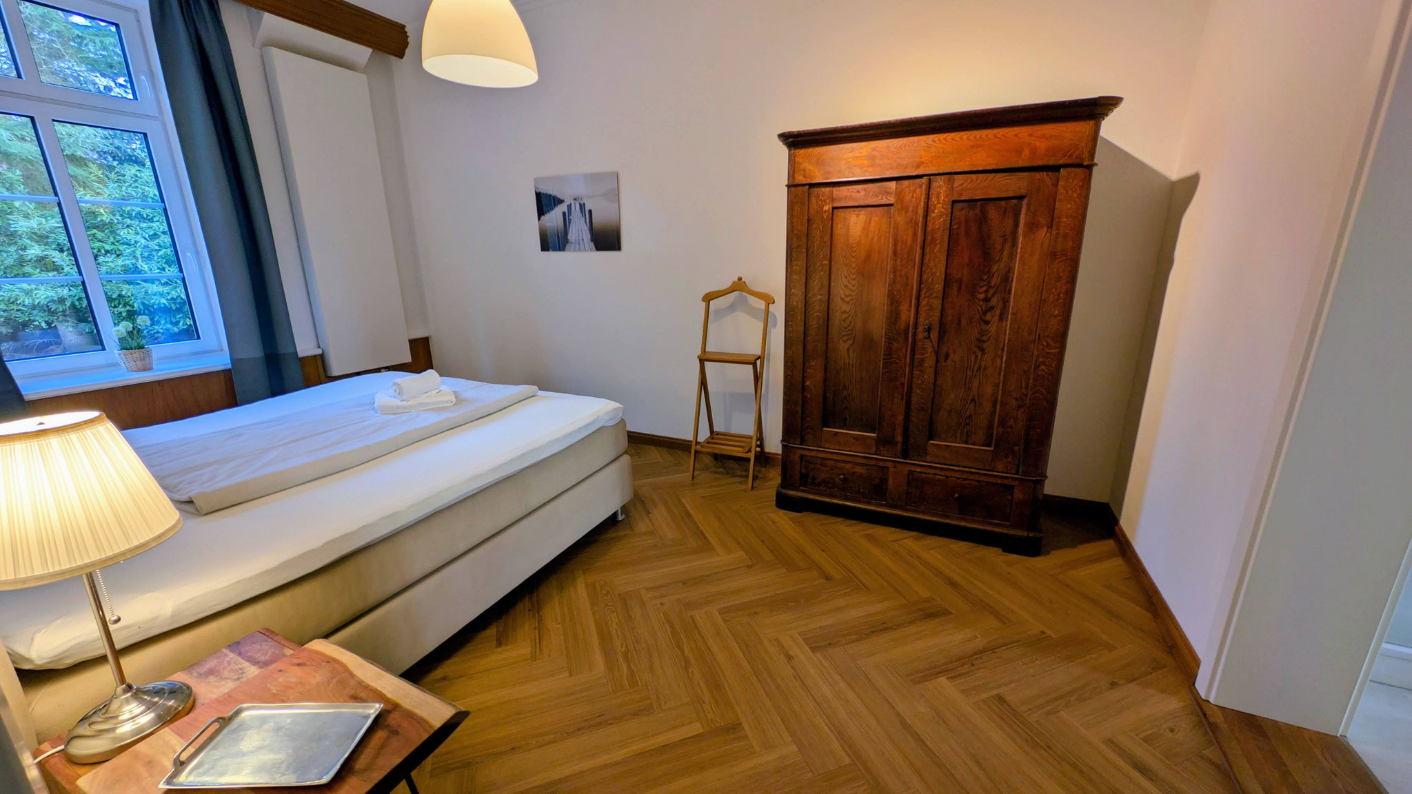 Luxus-Boxspringbett im Herrenzimmer-Stil – komfortabler Schlafbereich im historischen Ferienhaus auf der Insel Fehmarn.