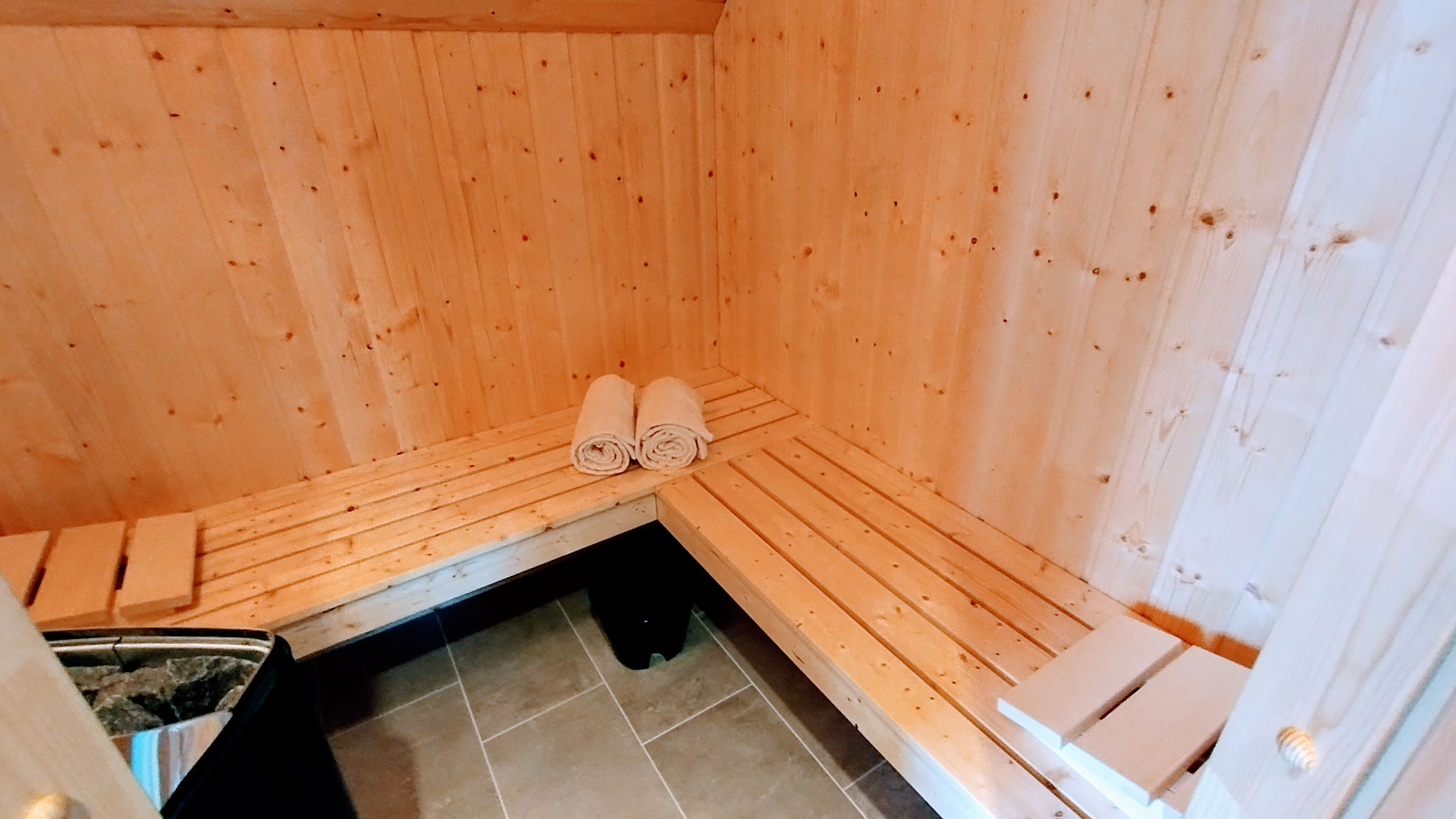 Wellnessbereich im Ferienhaus auf Fehmarn: Badezimmer mit eigener Sauna für entspannte Urlaubstage - Blick in die Sauna