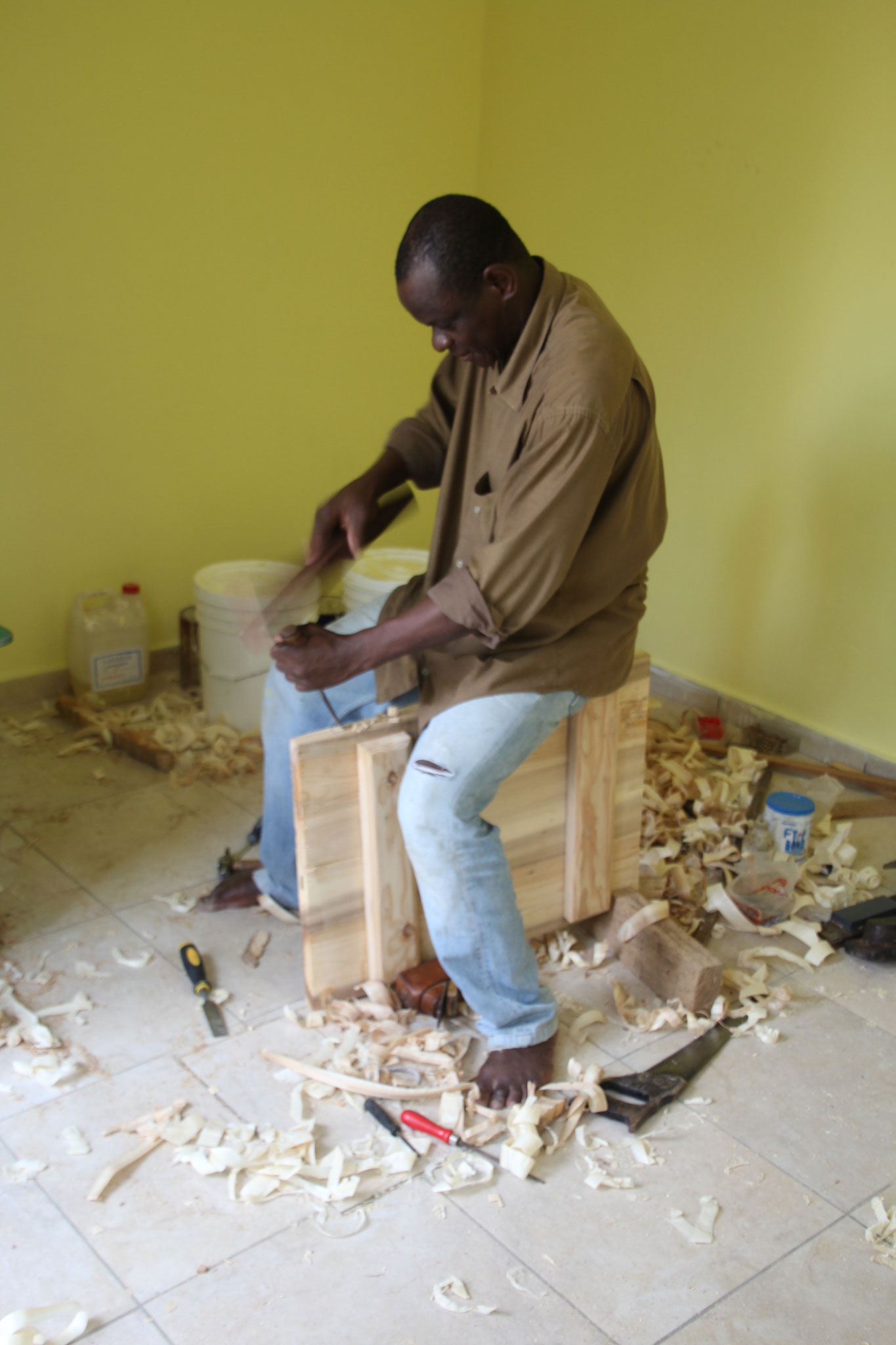 Soumagbo Amevi, der Schreiner passt eine Kastenzüre zum Wandschrank an.