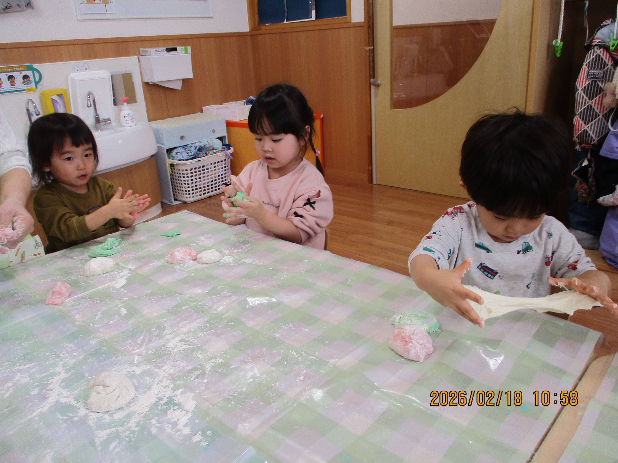 2歳児クラスで小麦粉粘土遊び。のばしたり、丸めたり感触を楽しんでいます。