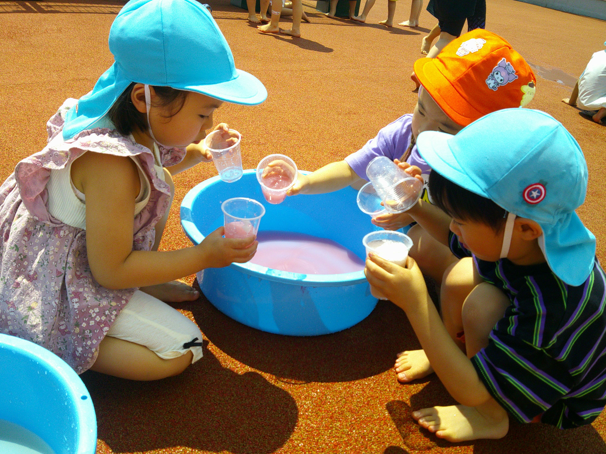 心地よい風が吹いている屋上で3・４・５歳児合同で色水あそびをしました。