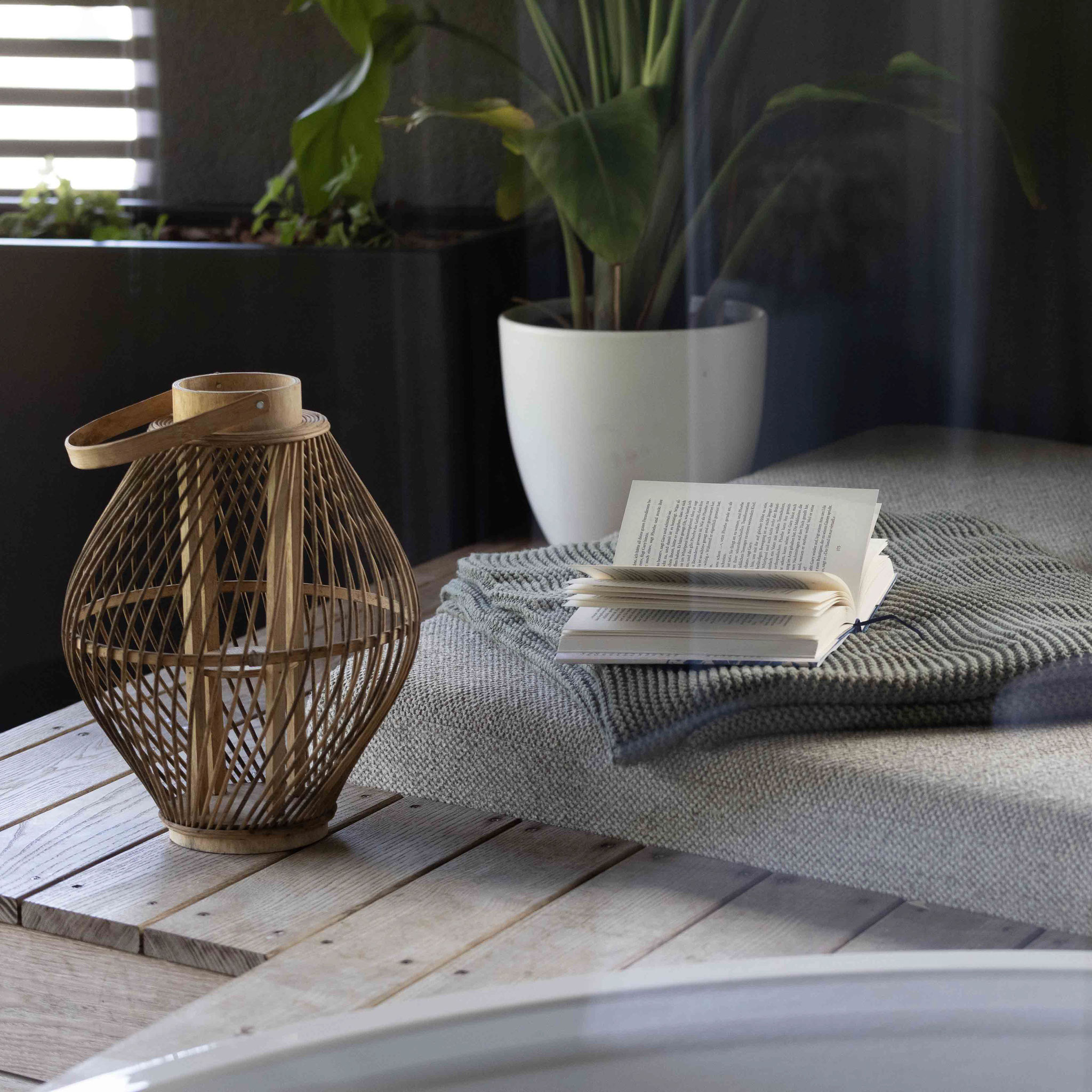 Gemütlicher Ruhebereich mit Liege, offenem Buch, weicher Decke und dekorativer Laterne im Boutiquehotel PETRUS in Reischach-Bruneck • Südtirol, ideal zum Lesen und Entspannen.