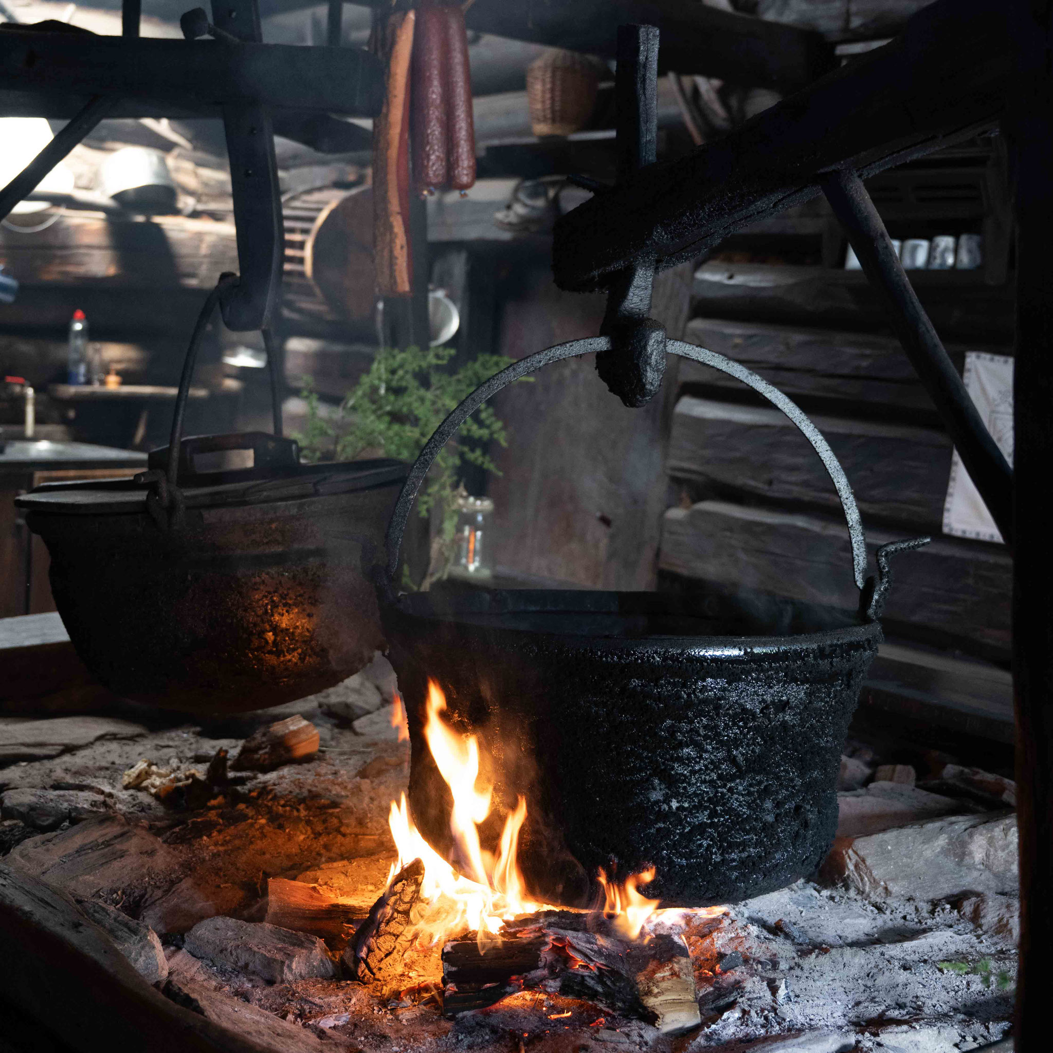 Historische Gusskessel über offenem Feuer in der Rauchkuchl der Karseggalm.