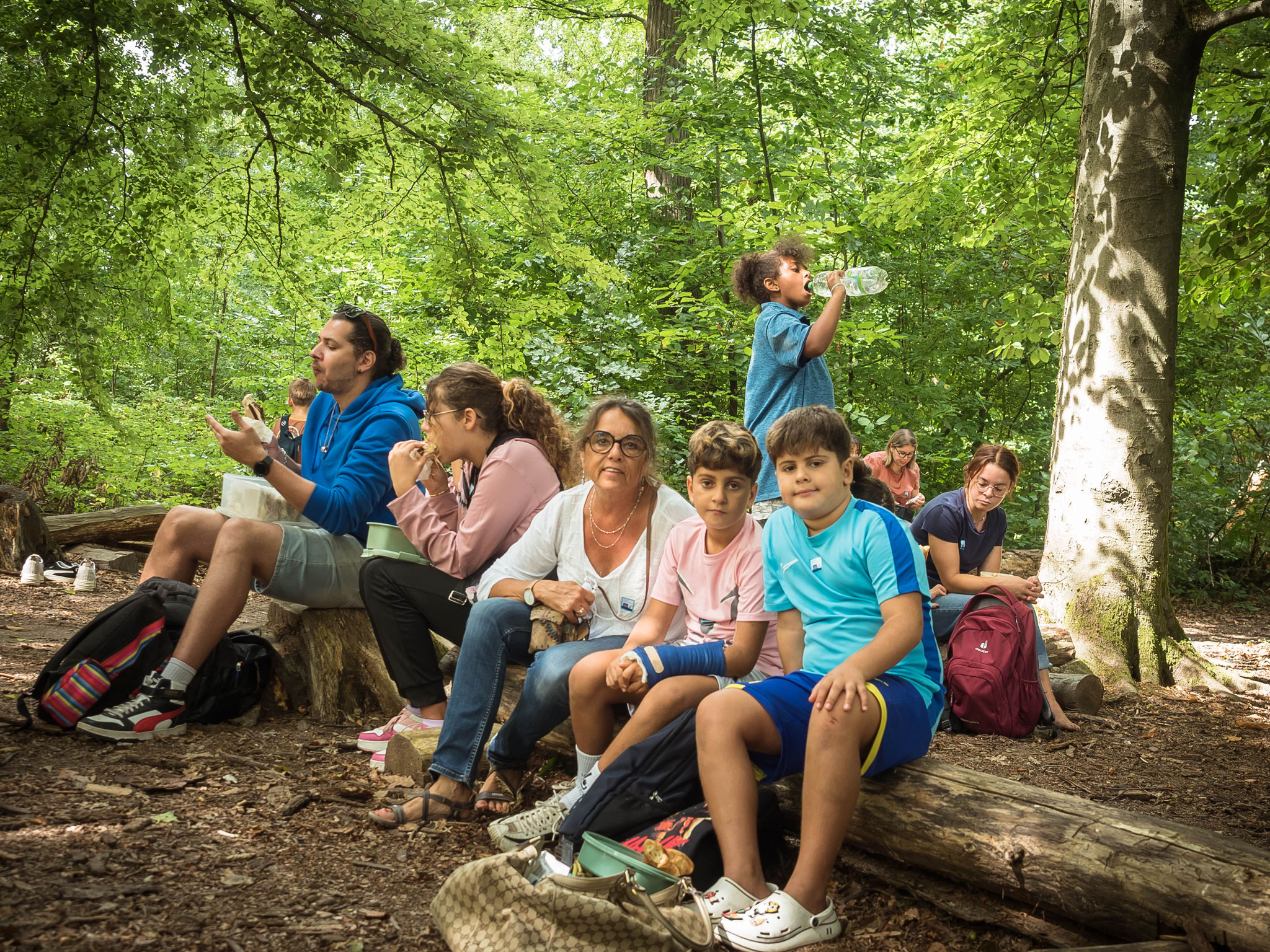 Menschen machen eine kleine Pause auf Baumstämmen sitzend 