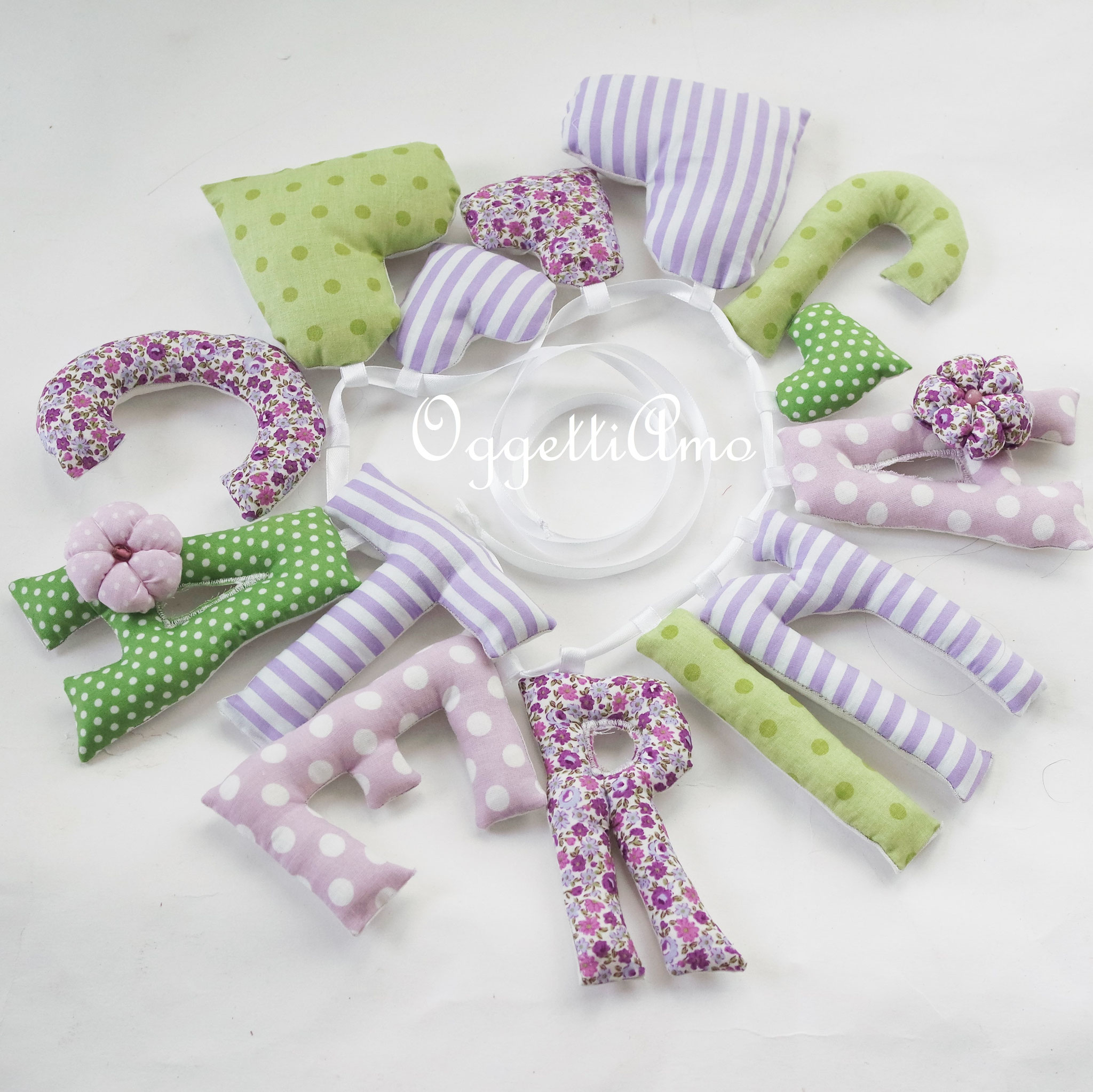 Una ghirlanda di lettere imbottite lilla, viola e verdi decorata con cuoricini per la piccola Caterina