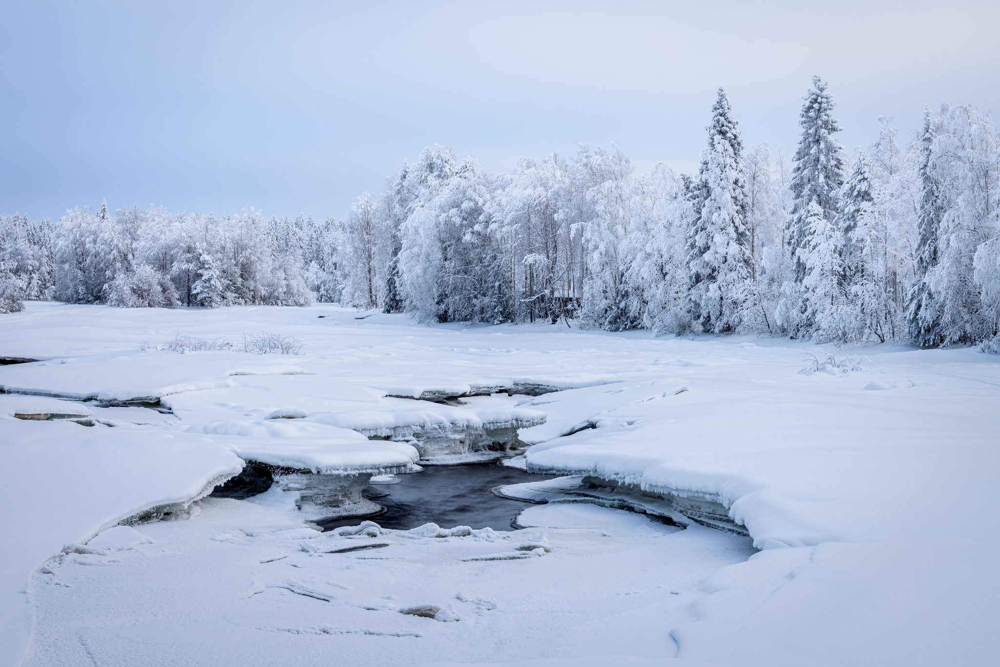 Winterlandschaft mit zugefrorenem Fluß in Nordfinnland