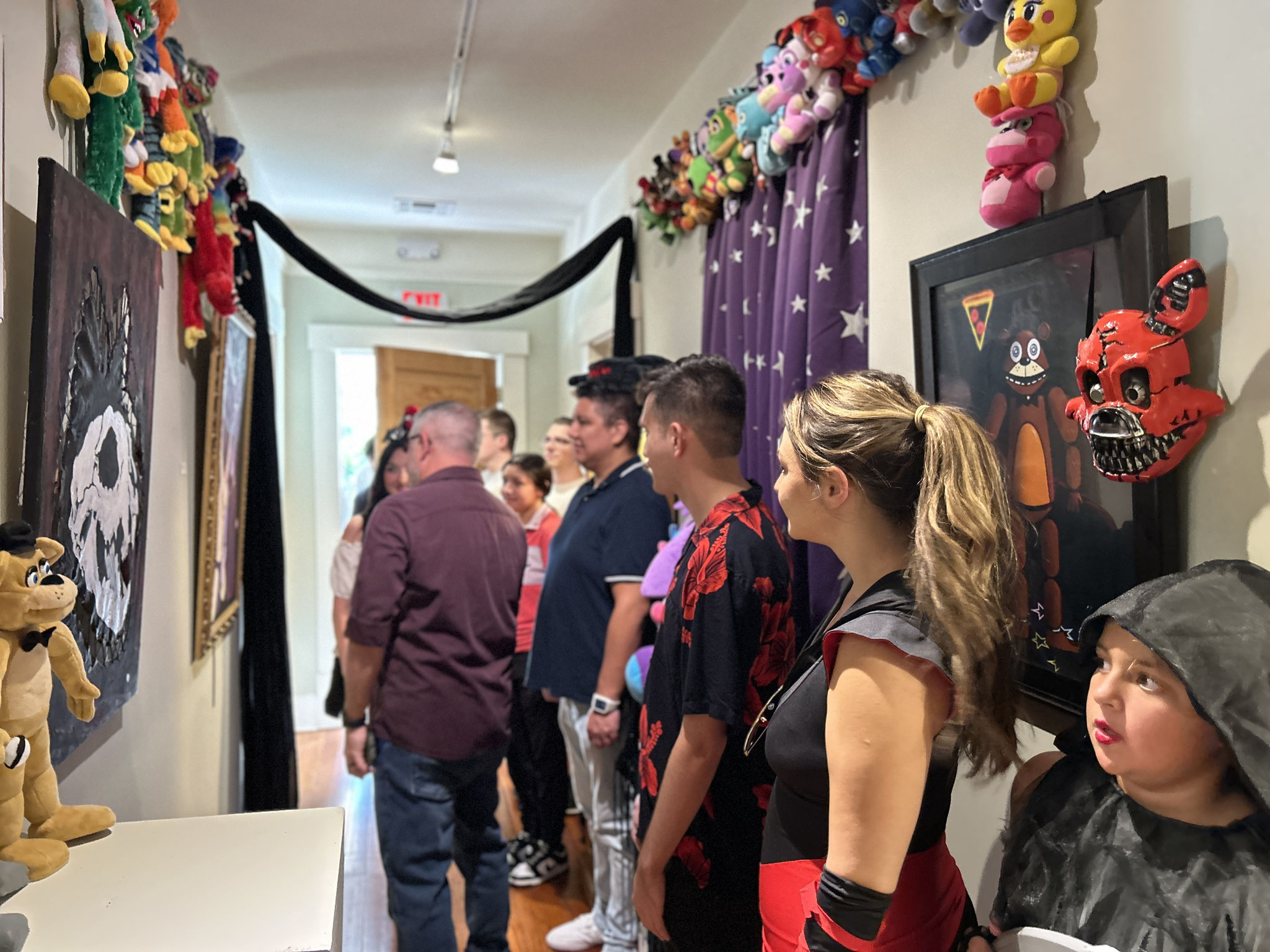 Guests view the Five Nights at Freddy's hallway with artwork by Fox Royer, Mattie Stark & Max Lay
