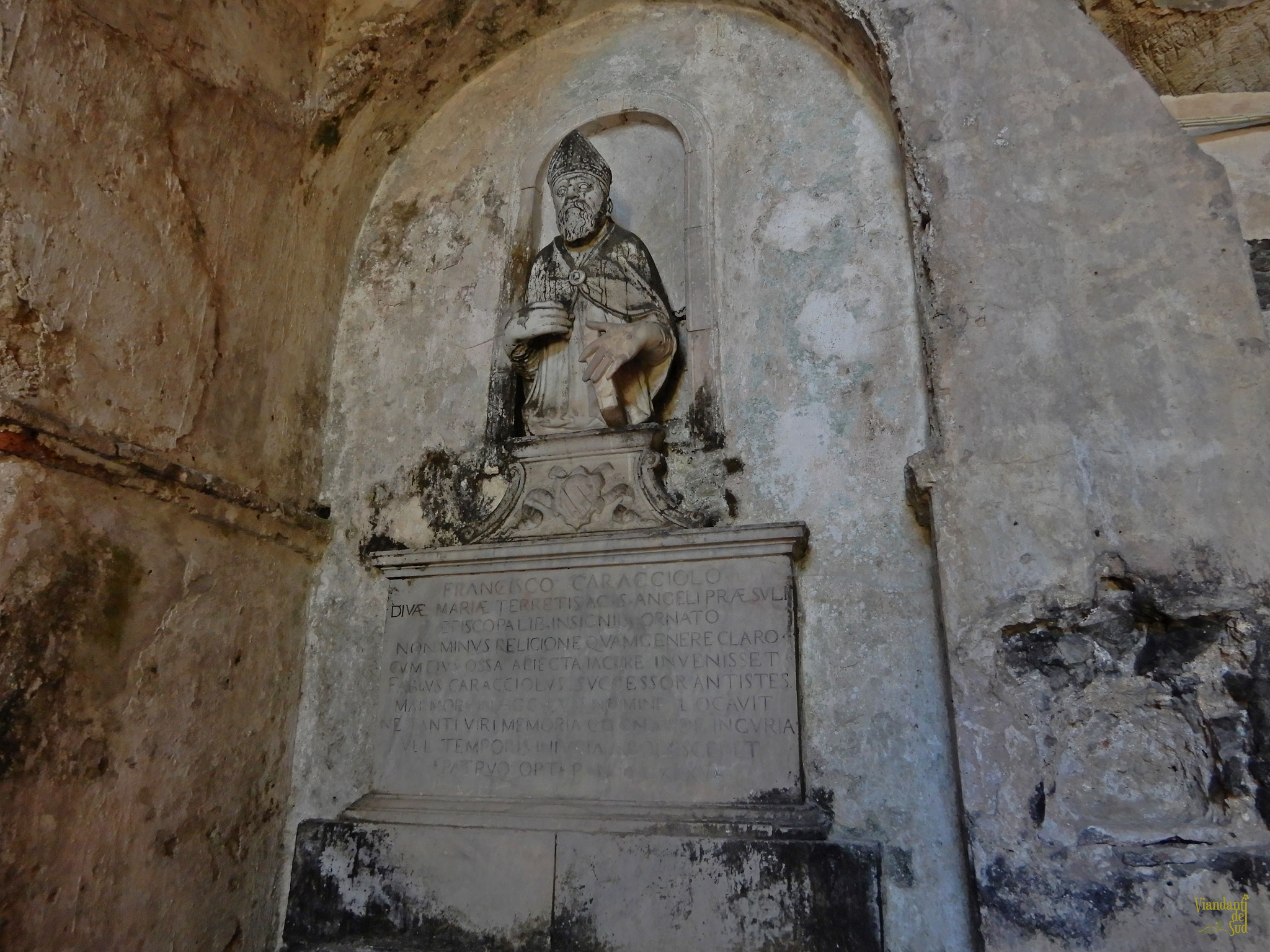 Entrando nella grotta, guardando di fronte, si può ammirare un monumento funerario del 1585 dell’Abate Francesco Caracciolo