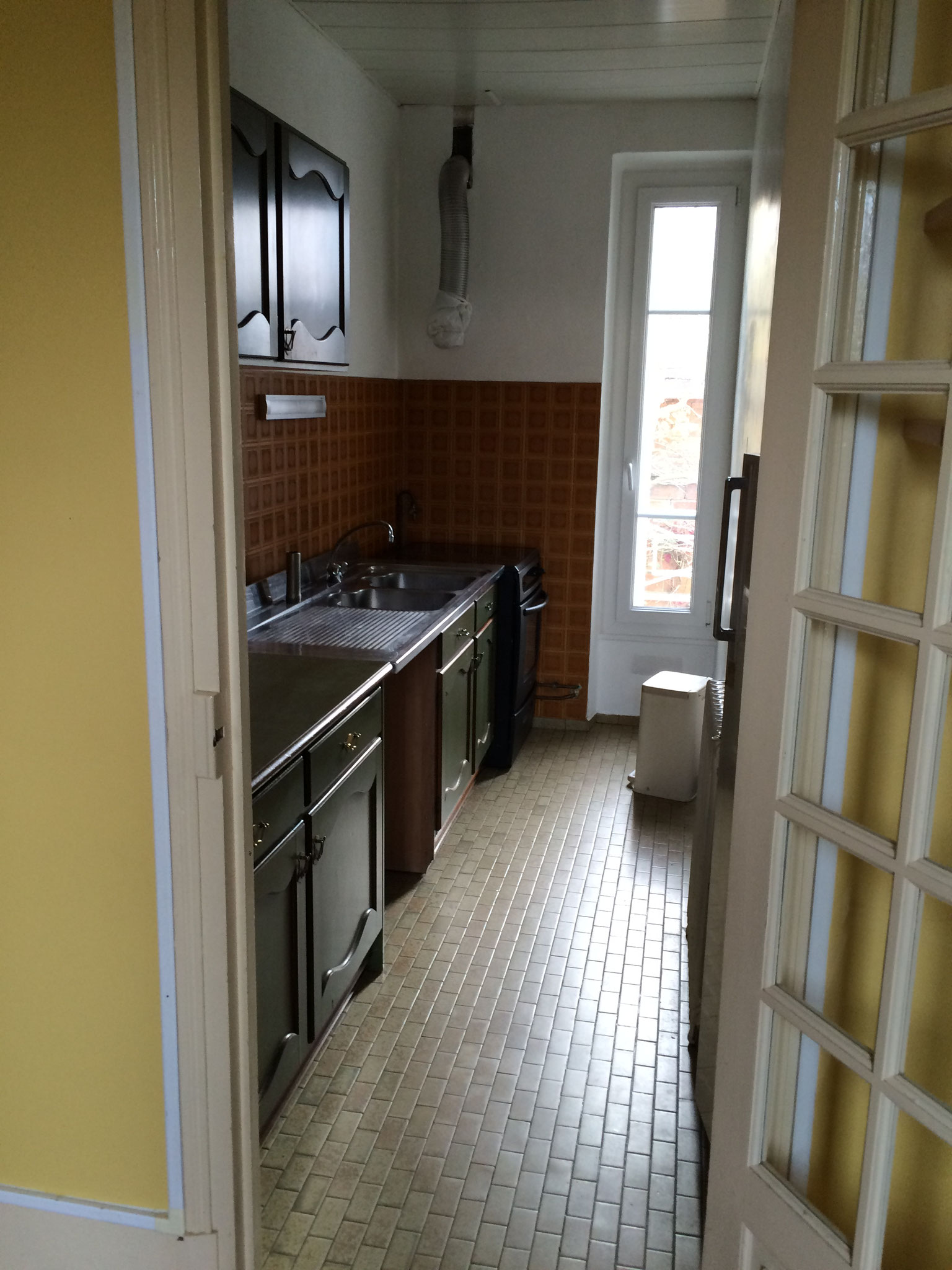 Cuisine étroite en forme de couloir avant rénovation, dans une maison meulière à Saint-Leu-la-Forêt.