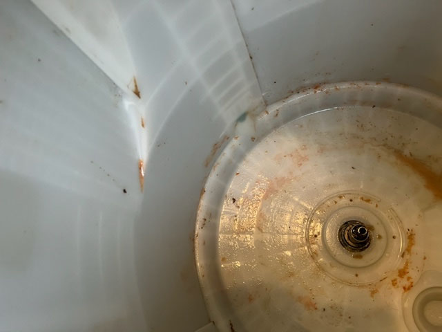 洗濯槽内部洗浄前の状態。裏側にカビや石鹸汚れが付着し、分解洗浄が必要な状態。