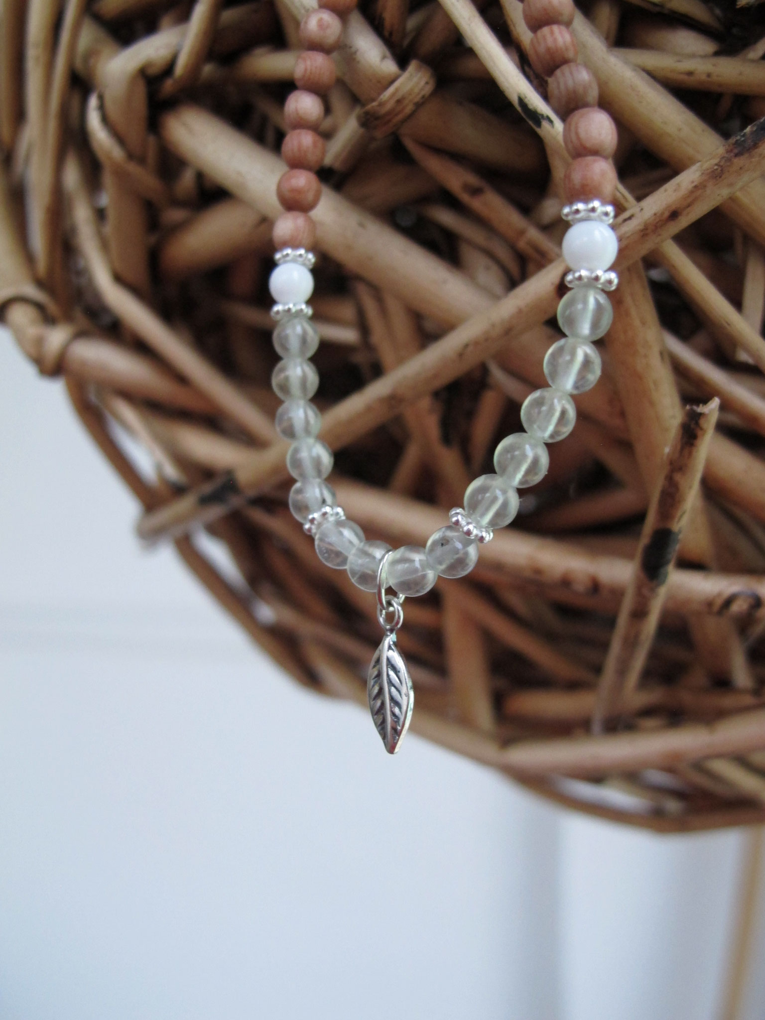 Gentle combination of rosewood and prehnite with dots of white jade and 925 Sterling silver leaf charm
