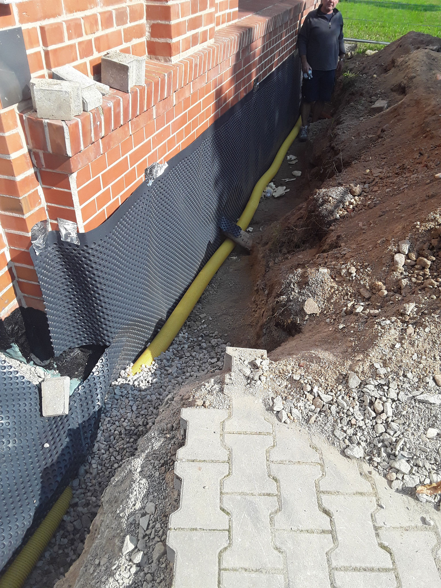 Verlegen der Noppenbahn und des Drainagerohrs