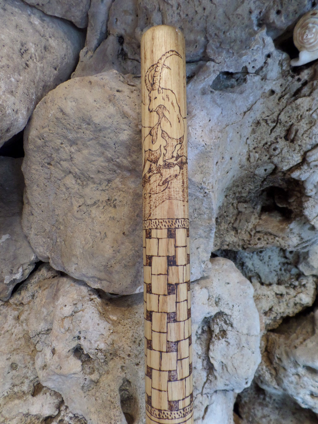 Steinbock und umlaufendes Muster