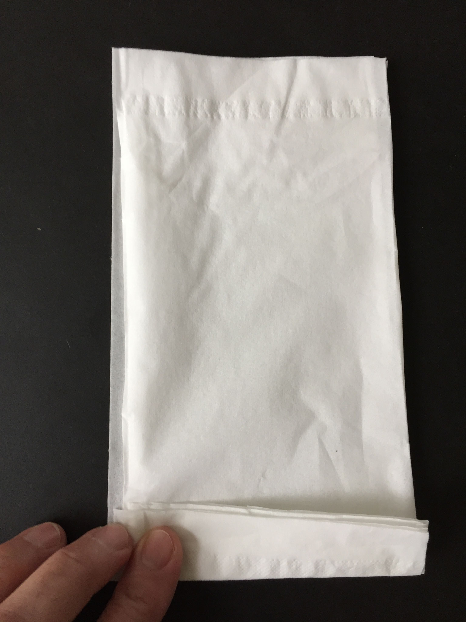 Jetzt faltest du sie von unten etwa so breit wie dein Daumen um.