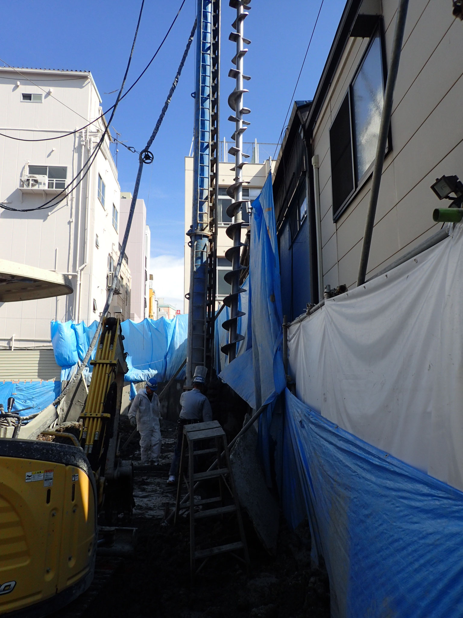 民家際ギリギリの施工。大きな機械では建物に影響が出る場面だ。
