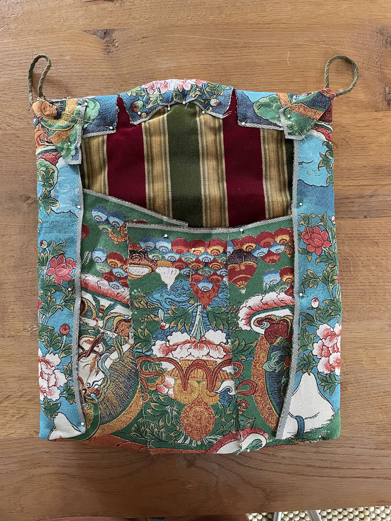As the fabric is a no-stretch stiff thing it needs cutting up to fold it in the shape of the cushion.