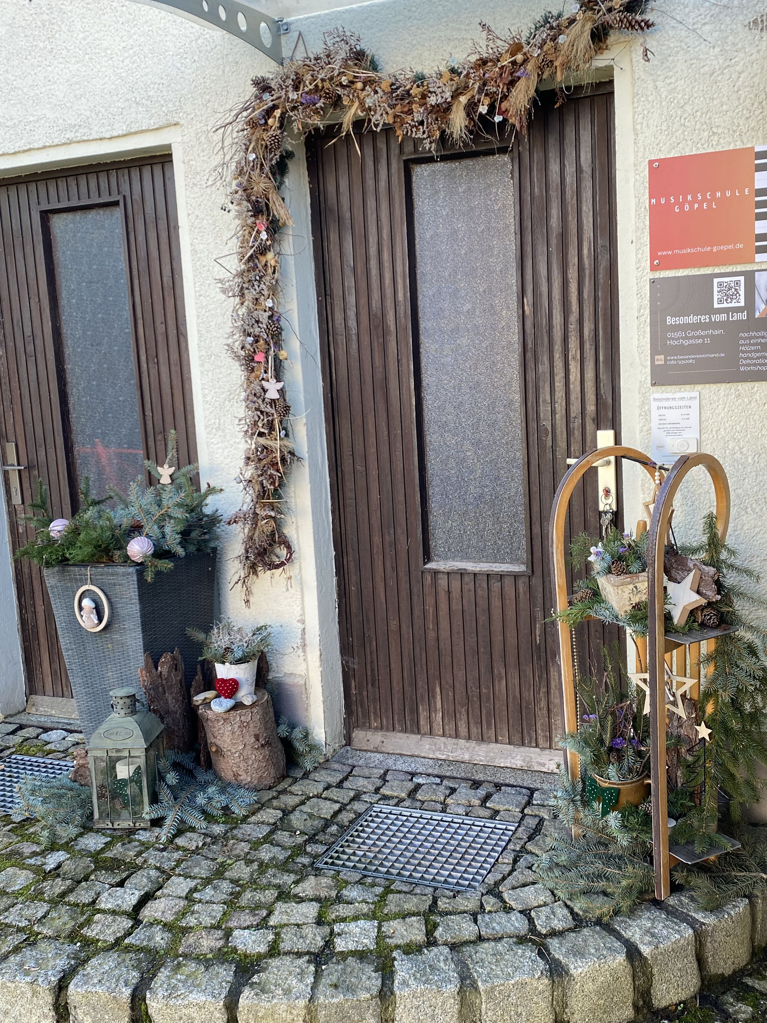 Eine schöne Winter Decho aus einem Schlitten mit Tannengrün steht vor unserem Laden.